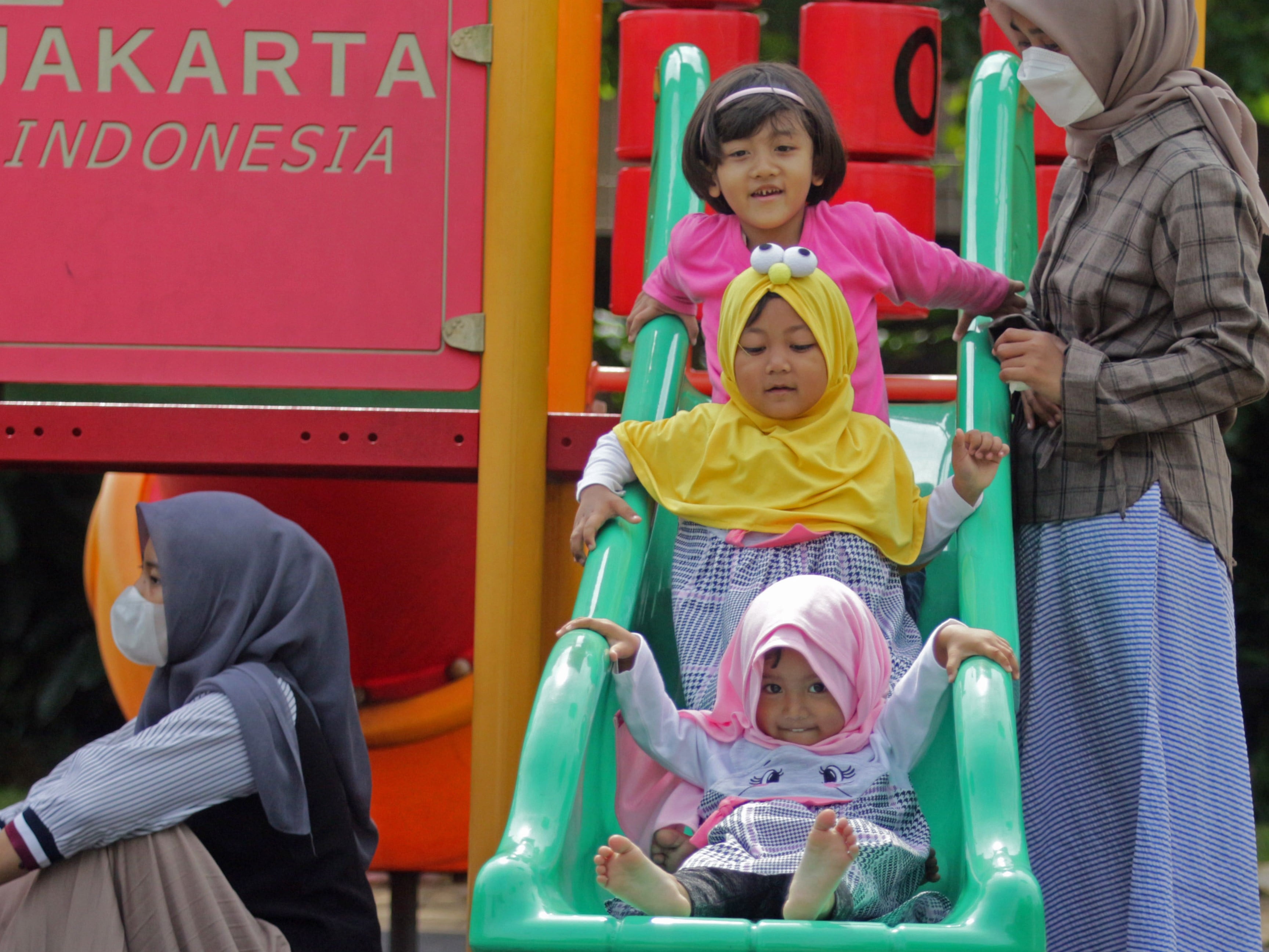 Orangtua mendampingi anaknya bermain di RPTRA Garuda, Cipayung, Jakarta Timur, Minggu (9/10/2022).