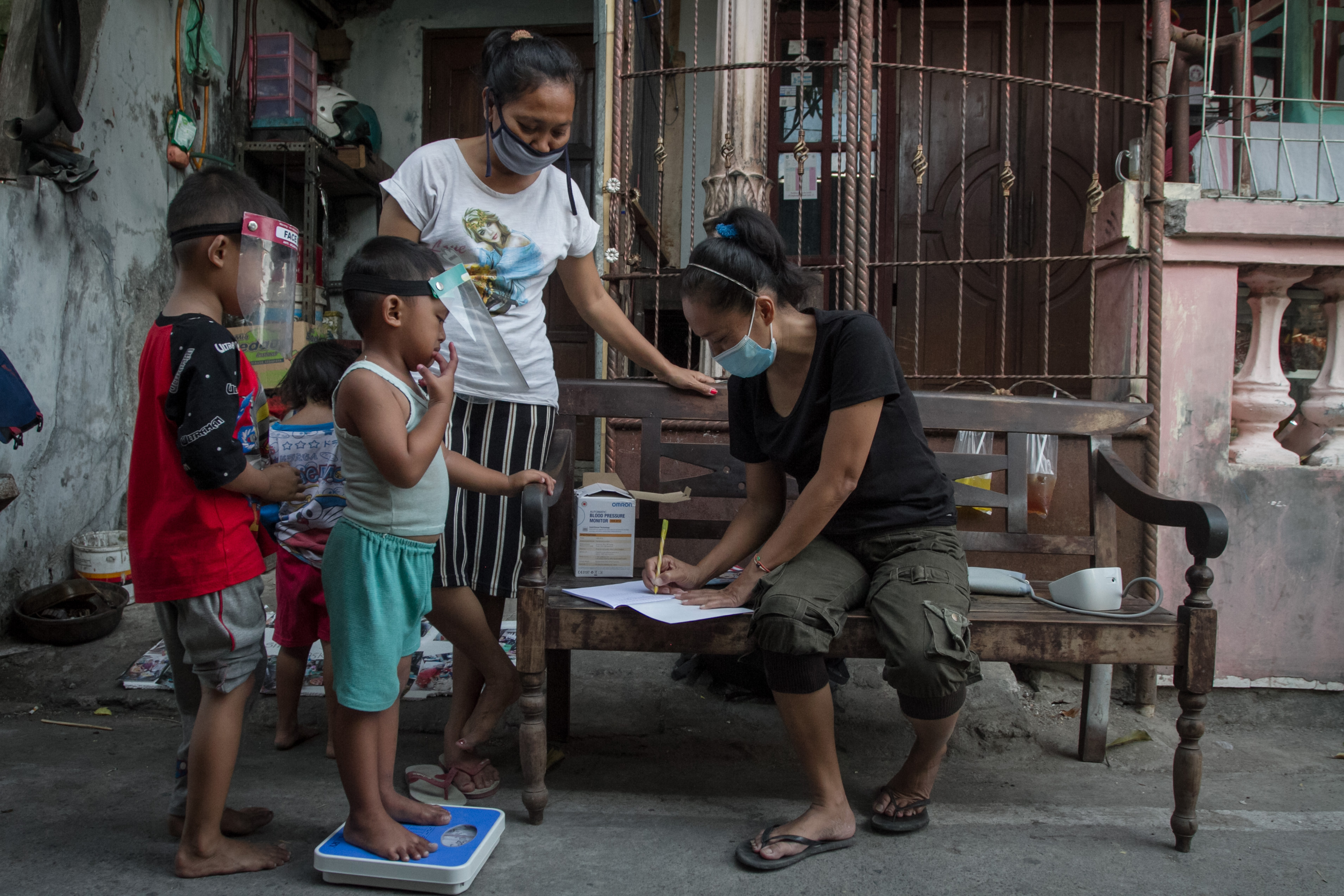 Potret relawan menimbang berat badan anak dalam kegiatan pemeriksaan kesehatan.