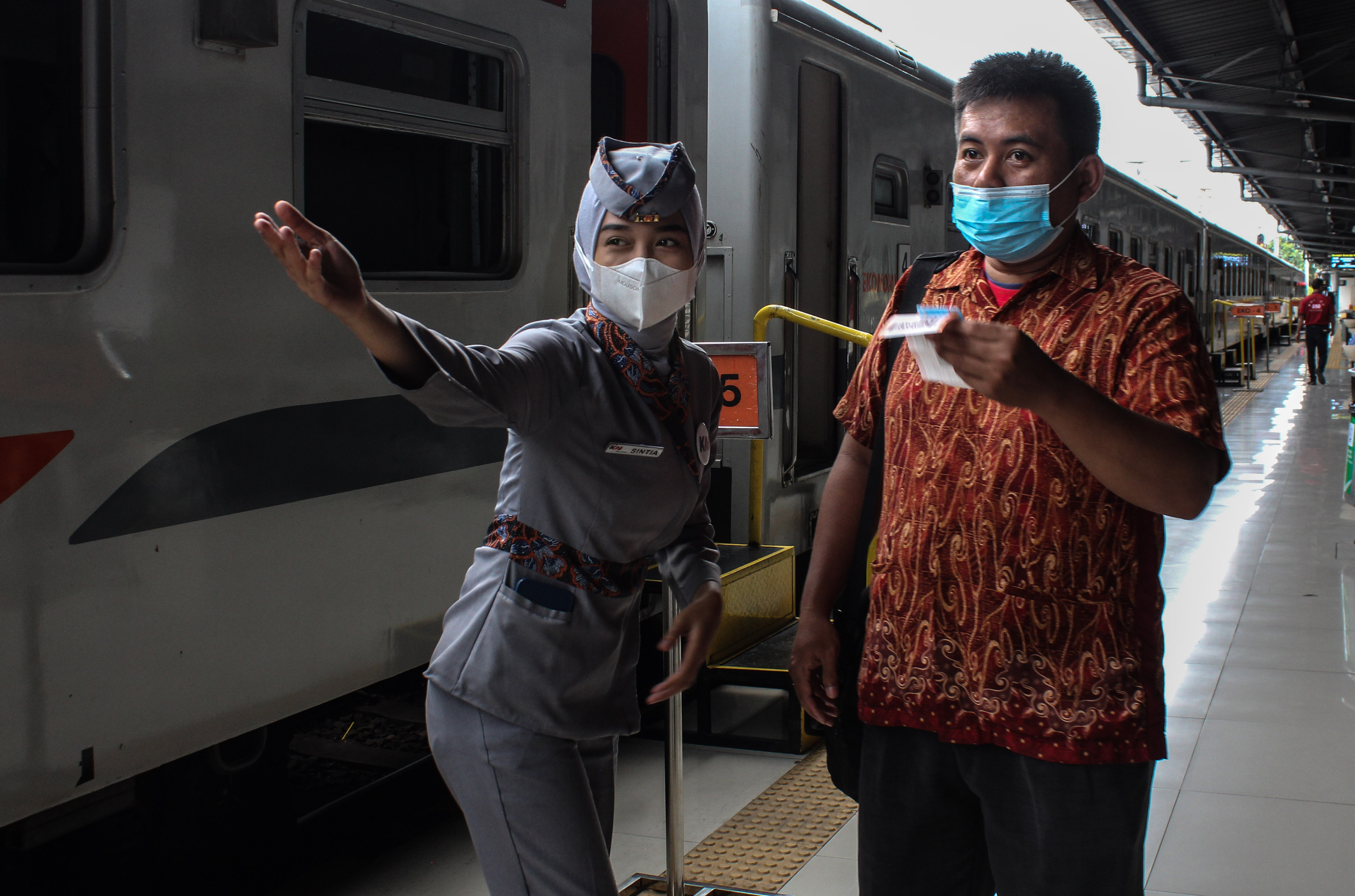 Petugas mengarahkan penumpang untuk menuju rangkaian kereta api di Stasiun Pasar Senen, Jakarta.