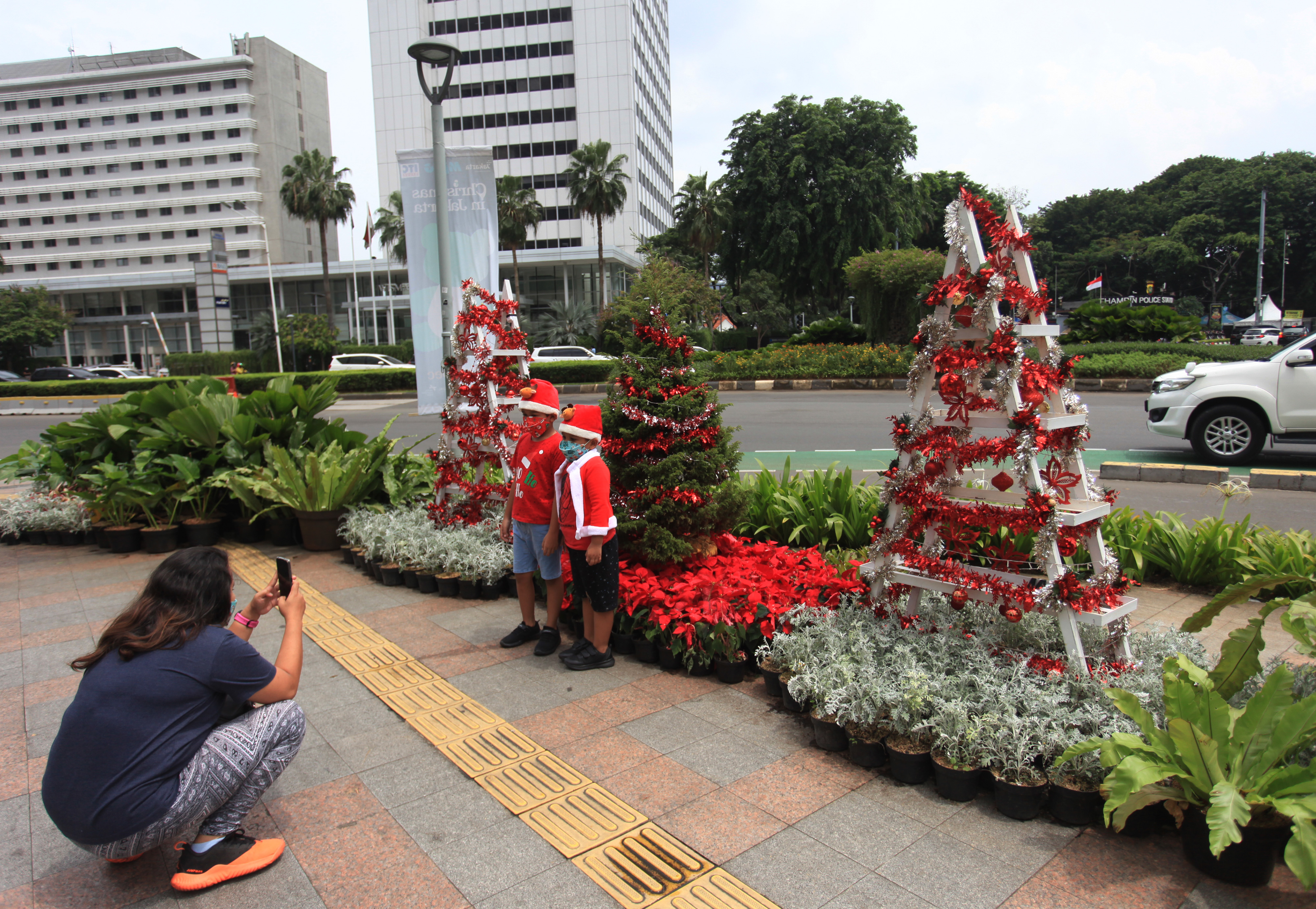 Dua anak berfoto di dekat hiasan pohon Natal yang terpajang di kawasan Bundaran Hotel Indonesia, Jakarta, tahun lalu.