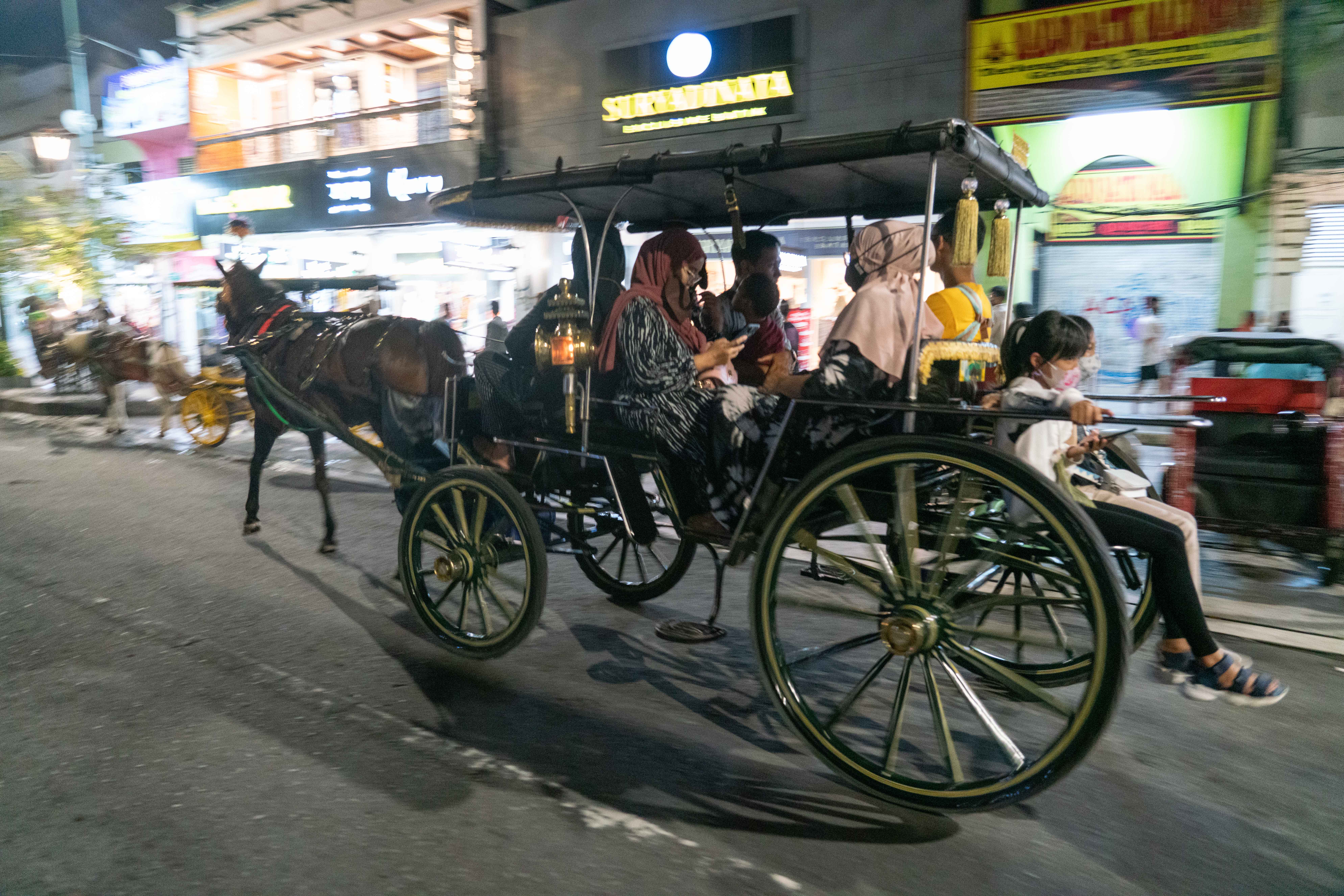 Wisatawan naik andong saat malam bebas kendaraan bermotor (car free night) di kawasan Malioboro, Danurejan, Yogyakarta.