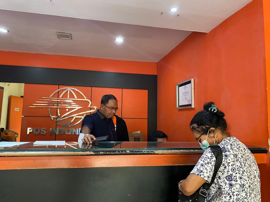 Serorang pekerja mengambil haknya menerima BSU di sebuah Kantor Pos. 