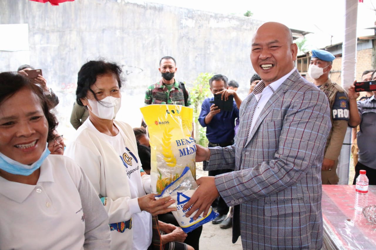 Bupati Tapanuli Utara, Sumatra Utara, Nikson Nababan menyerahkan beras kepada warga yang membeli di pasar murah