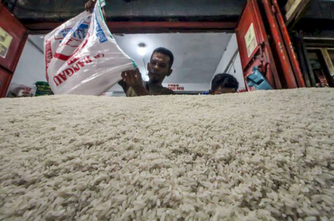 Penjual menuangkan beras eceran