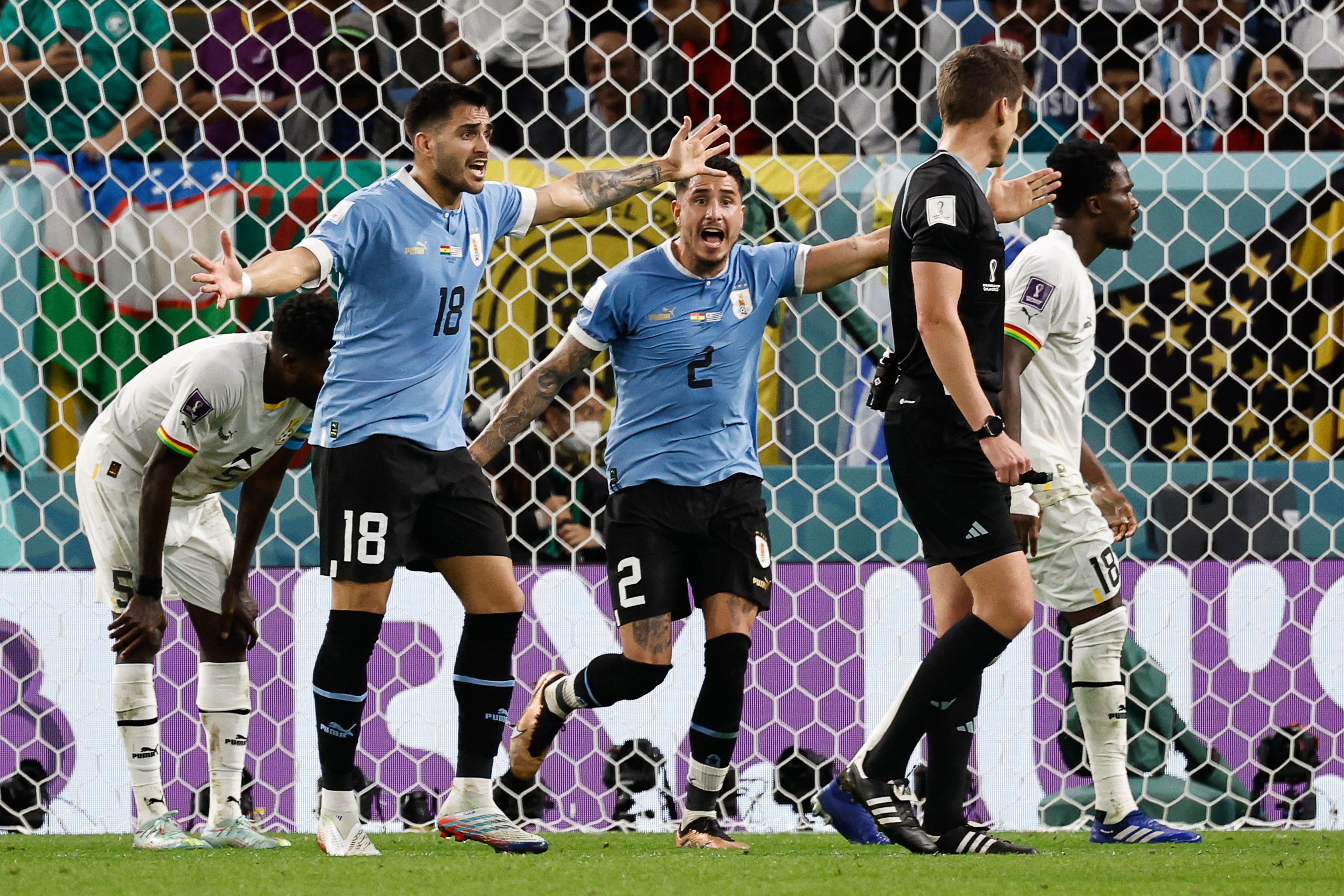 Dua pemain Uruguay memprotes keputusan wasit Daniel Siebert di laga Piala Dunia 2022 melawan Ghana.