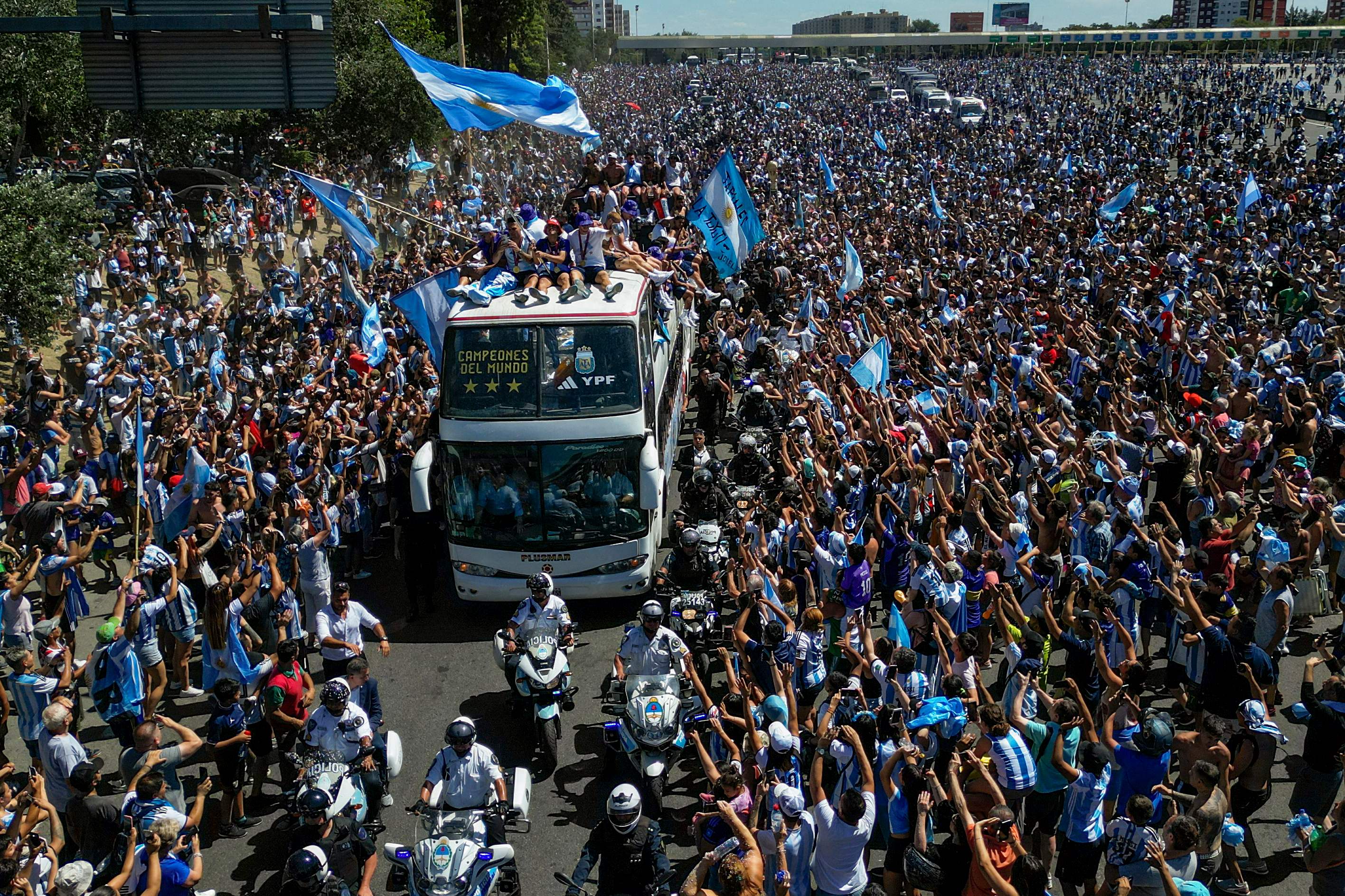 Pemain timnas Argentina menumpang bus yang membawa mereka melintas di Buenos Aires disambut para pendukung.