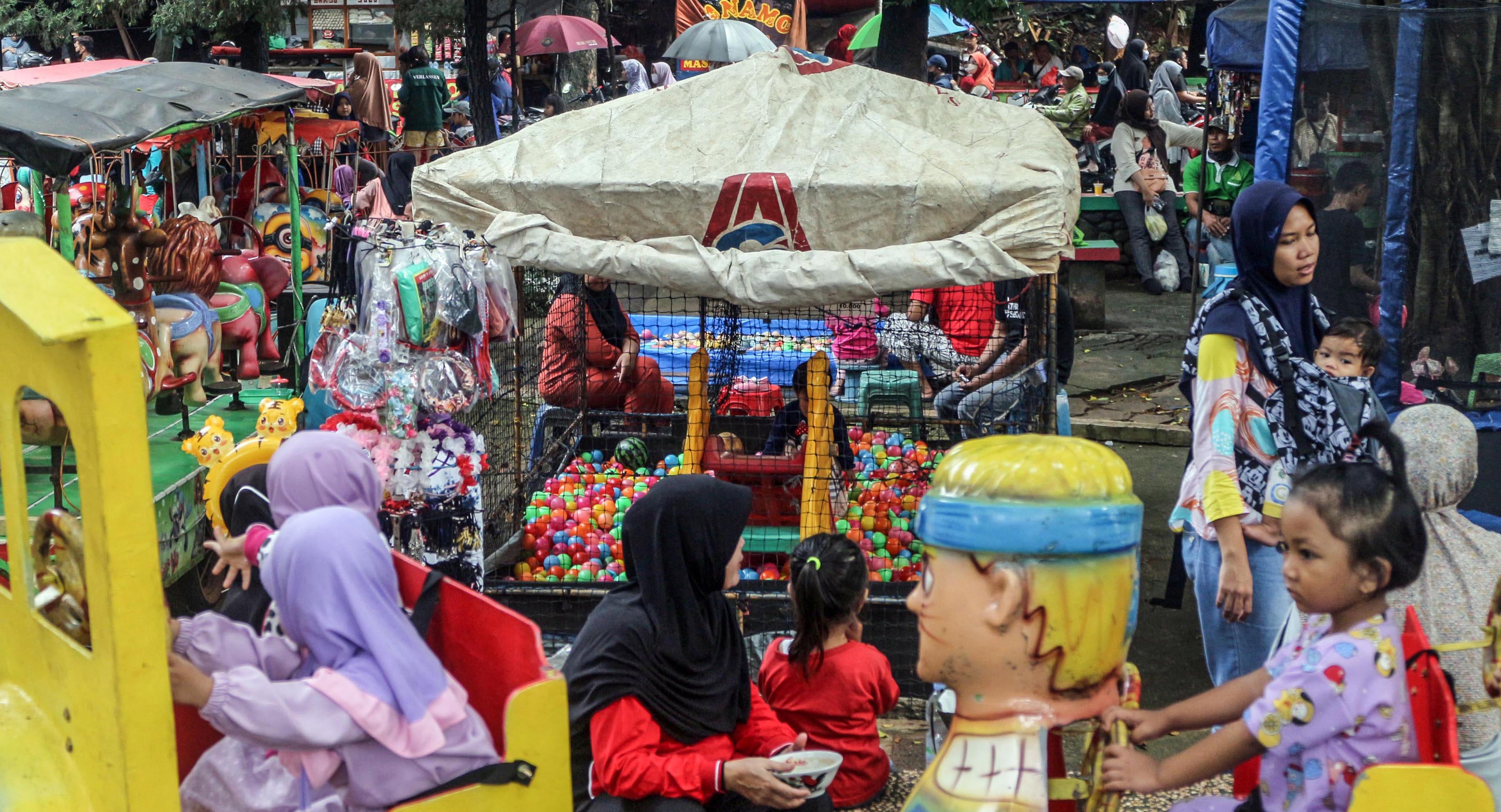 Sejumlah anak menaiki wahana di ruang publik, Taman Merdeka, Depok, Jawa Barat.