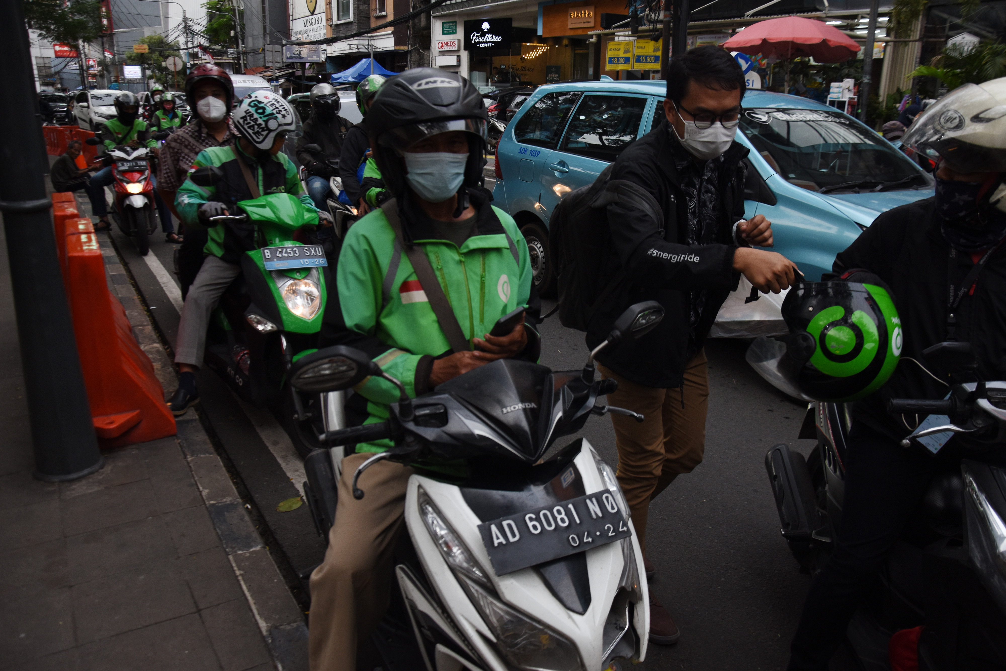 Pengendara Gojek mengangkut penumpang di Stasiun Sudirman, Jakarta.