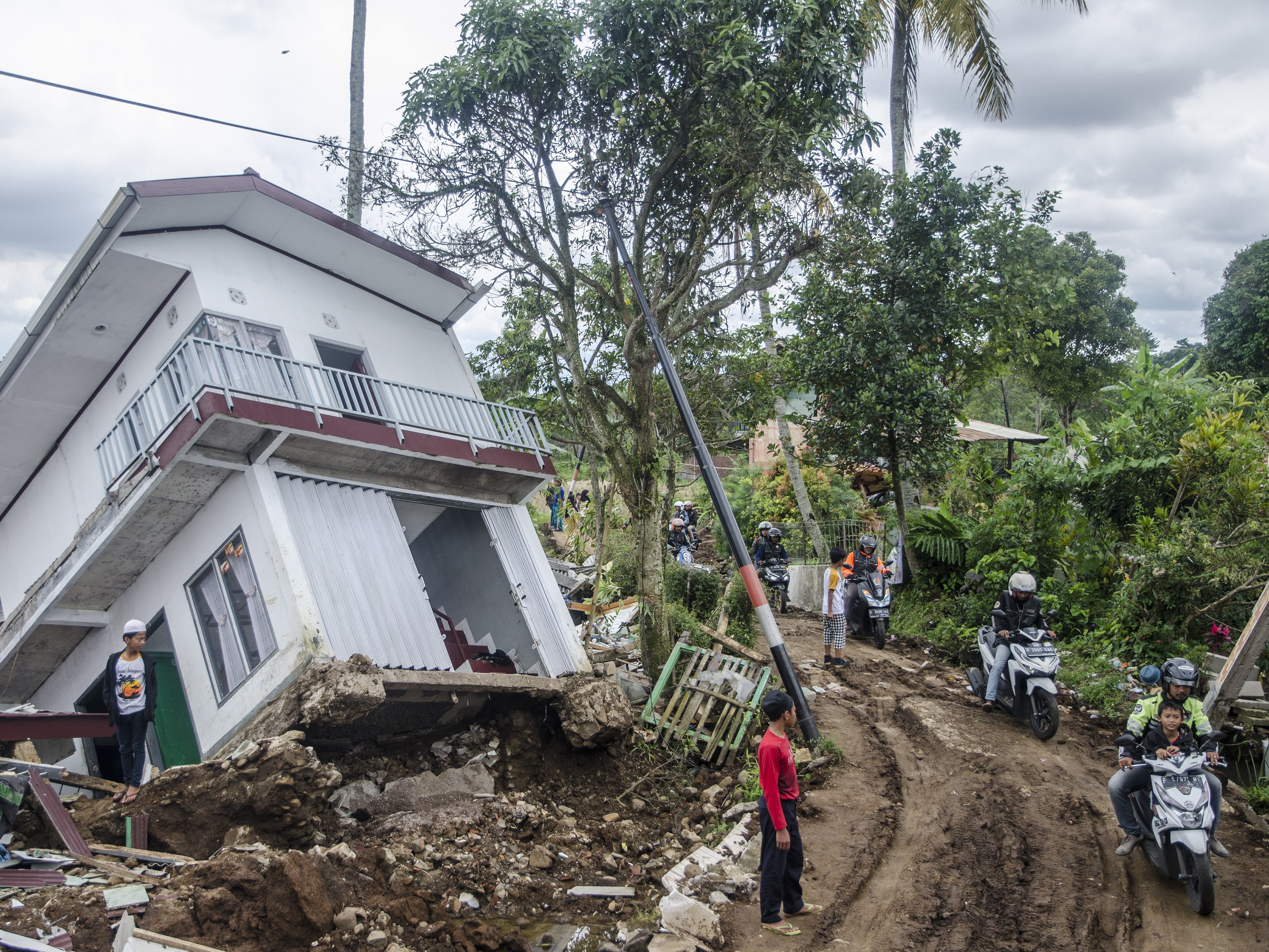Warga melintasi area terdampak gempa di Sarampad, Kabupaten Cianjur, Jawa Barat, Minggu (27/11/2022).