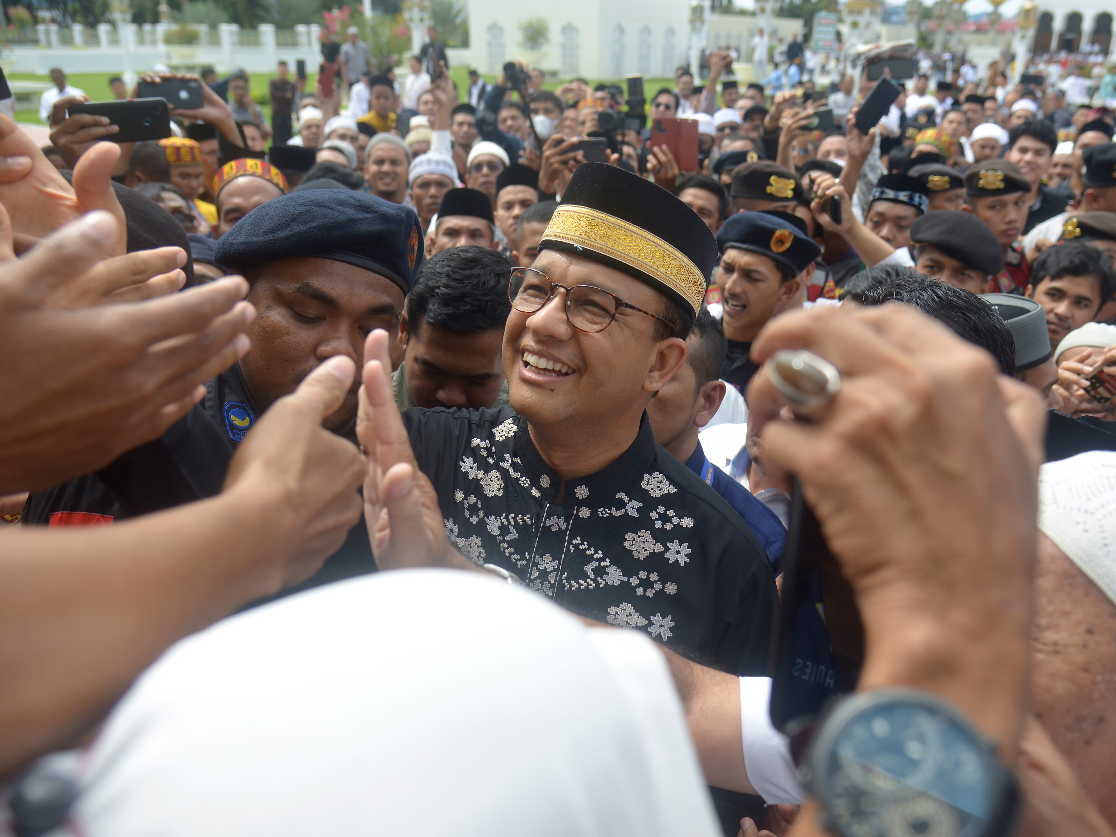 Anies Baswedan berjabat tangan dengan warga seusai melaksanakan salat Jumat di Masjid Raya Baiturrahman, Banda Aceh, Jumat (2/12/2022).