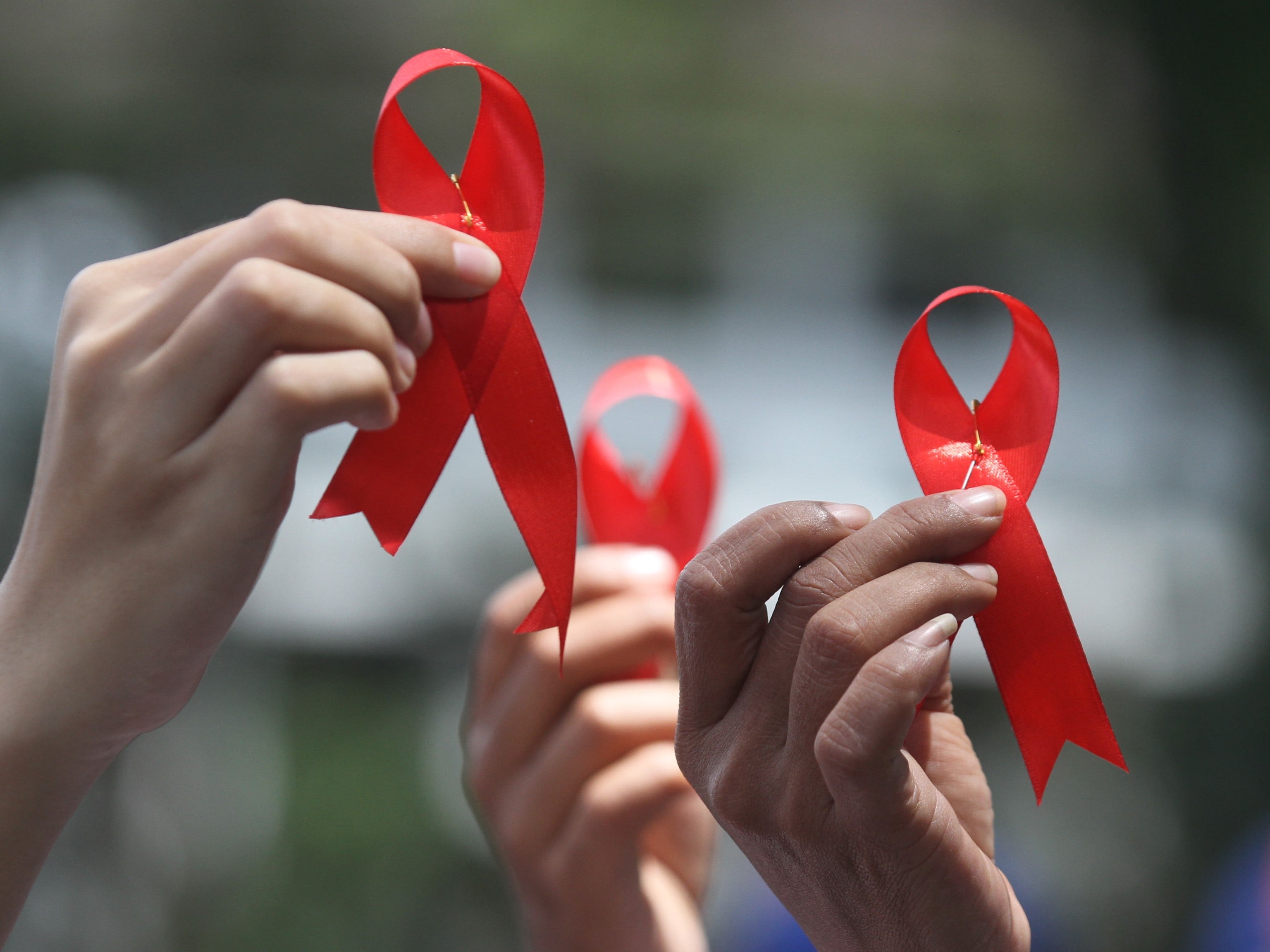 Anggota komunitas Jaringan Lintas Isu (JATI) menunjukkan pita merah saat berunjuk rasa memperingati Hari AIDS sedunia.