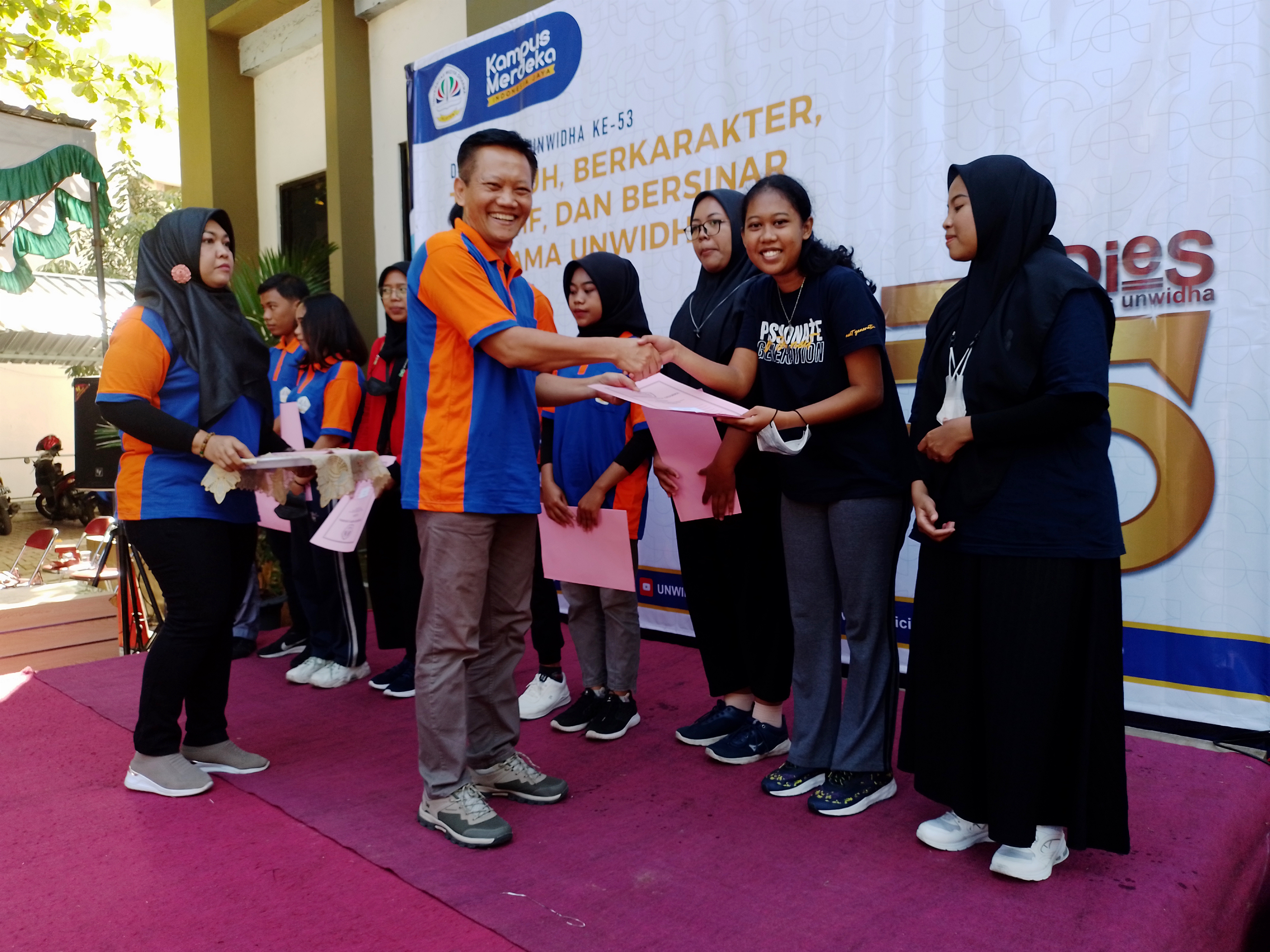  Wakil Rektor III Universitas Widya Dharma Klaten, Daru Pratomo, menyerahan beasiswa kepada mahasiswa.