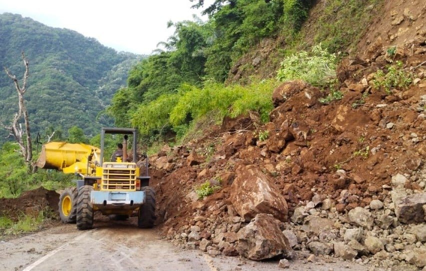 Petugas dinas PUPR masih membersihkan material yang longsor menutupi akses jalan