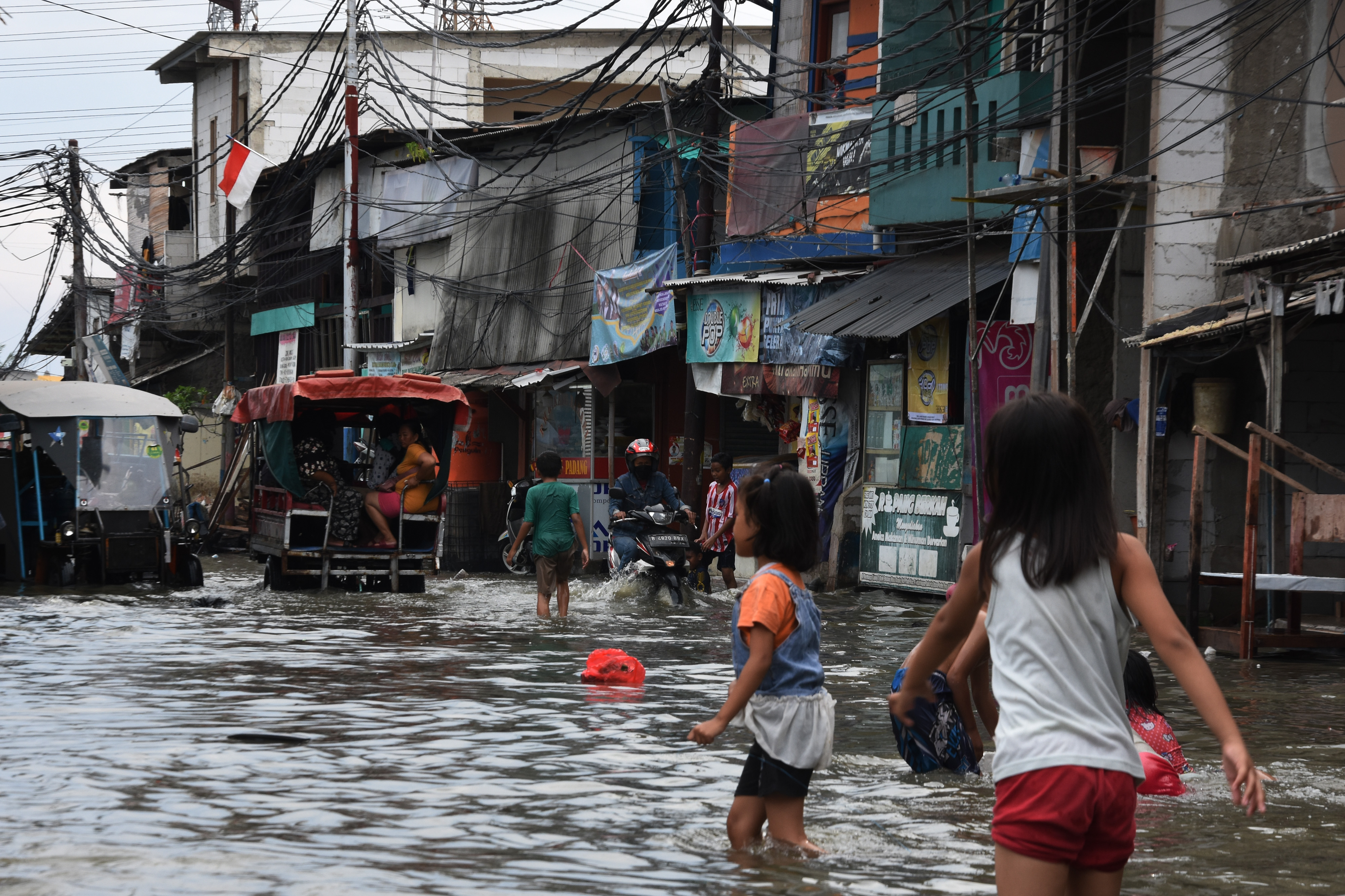 Sejumlah anak bermain saat banjir melanda kawasan Muara Angke, Penjaringan, Jakarta.