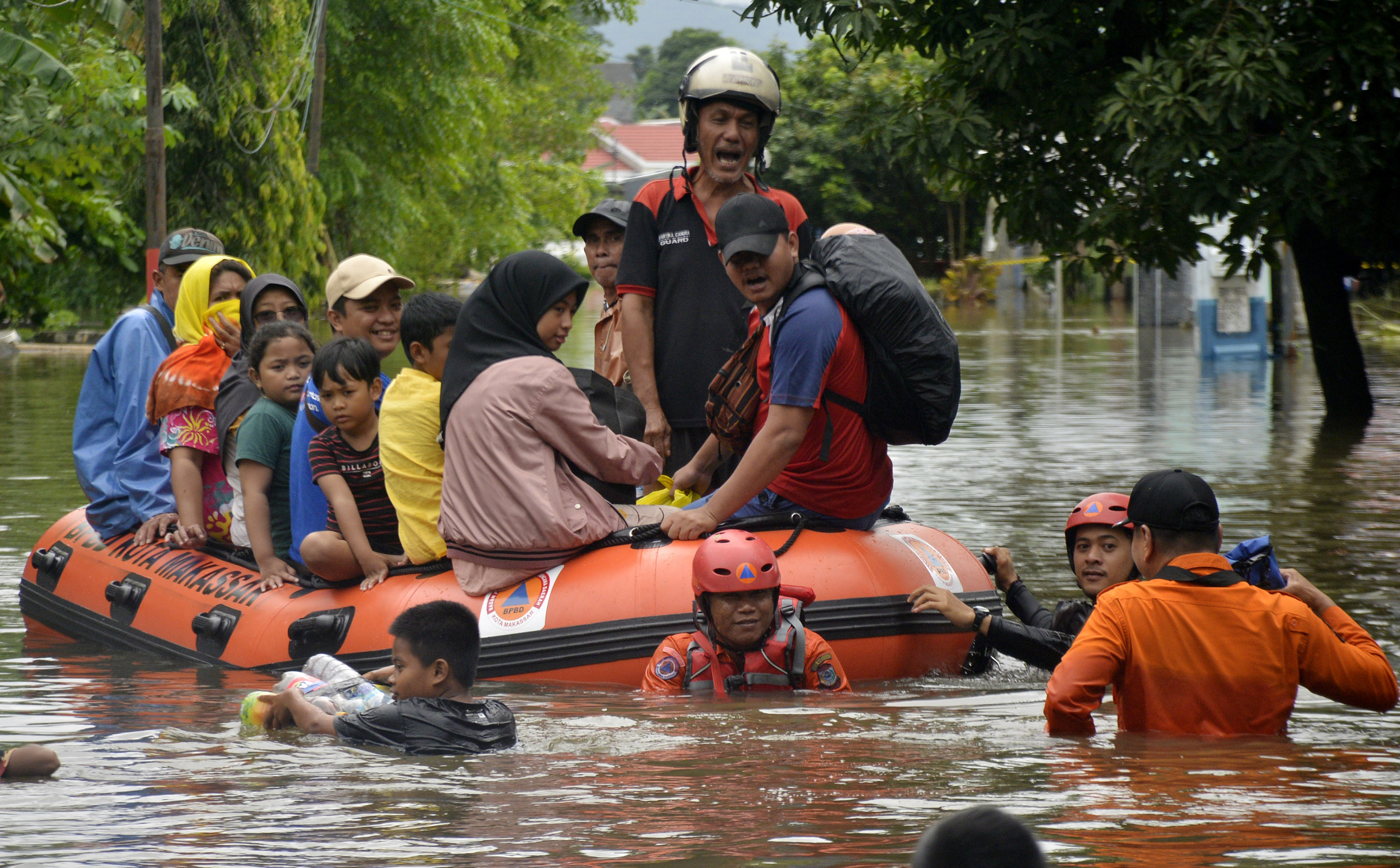 Warga korban terdampak banjir dengan menggunakan perahu karet di Perumahan Antang, Makassar, Sulawesi Selatan, Minggu (25/12).