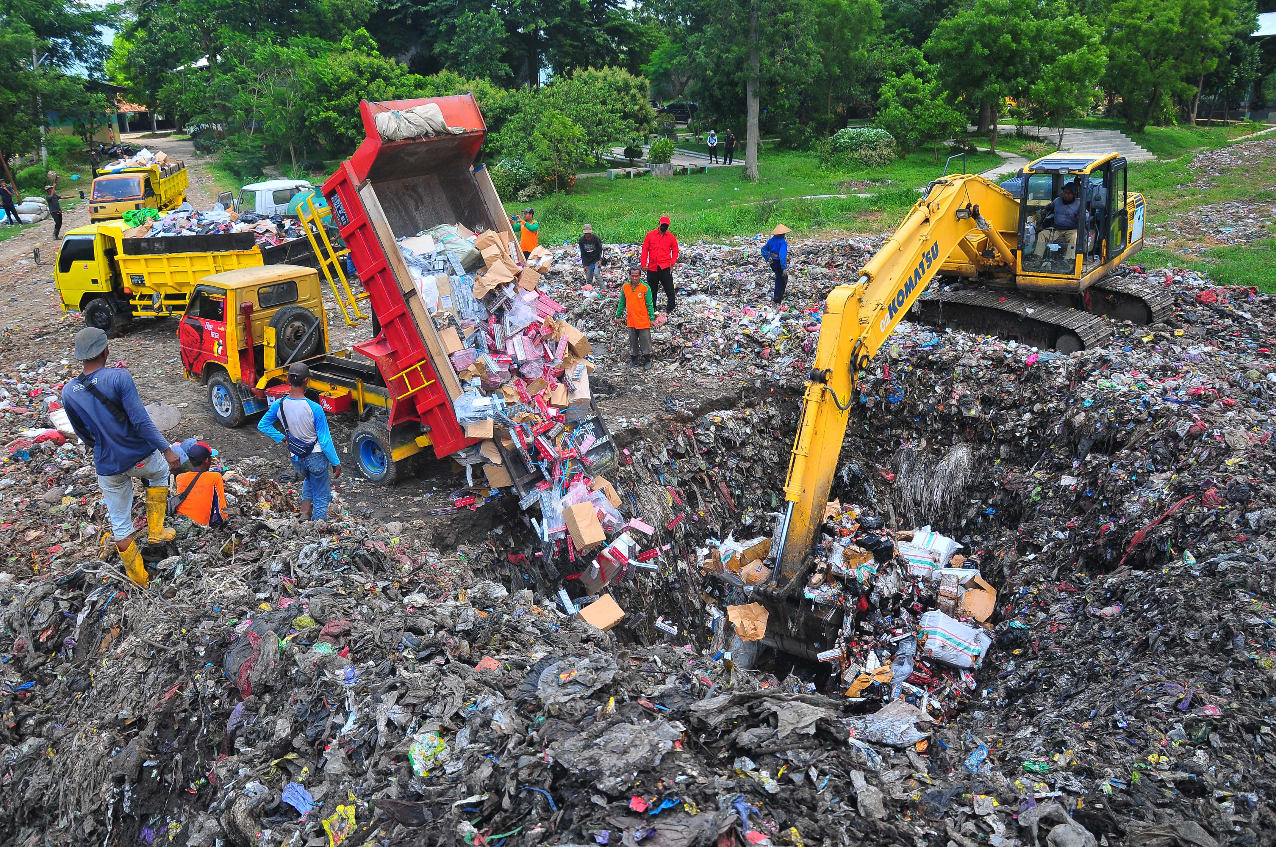 Petugas menggunakan alat berat memusnahkan rokok ilegal dengan mengubur di TPA Tanjungrejo, Kudus, Jawa Tengah, Rabu (21/12).