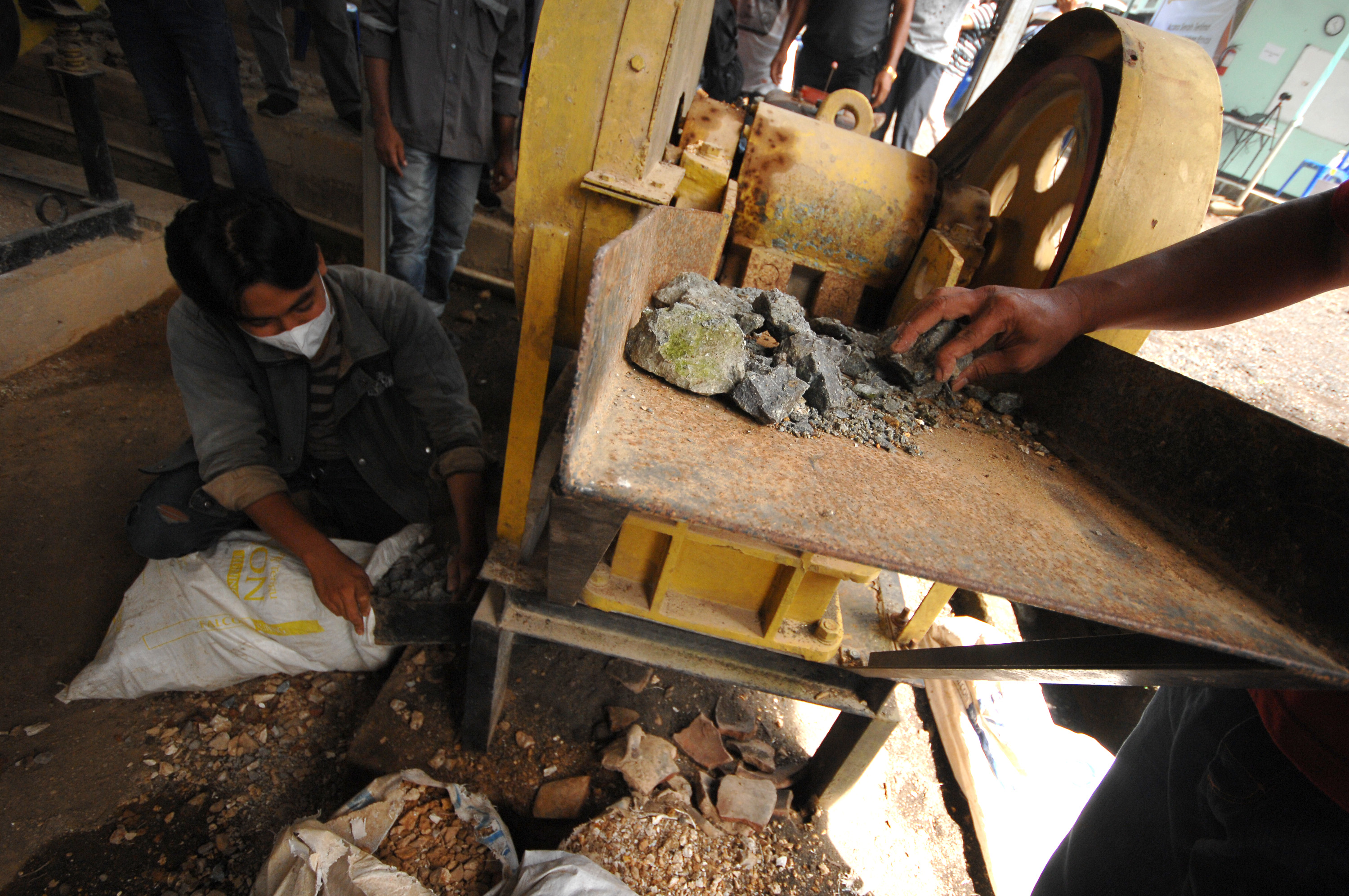 Pekerja menghancurkan material galian di lokasi pertambangan emas rakyat Desa Tatelu, Minahasa Utara