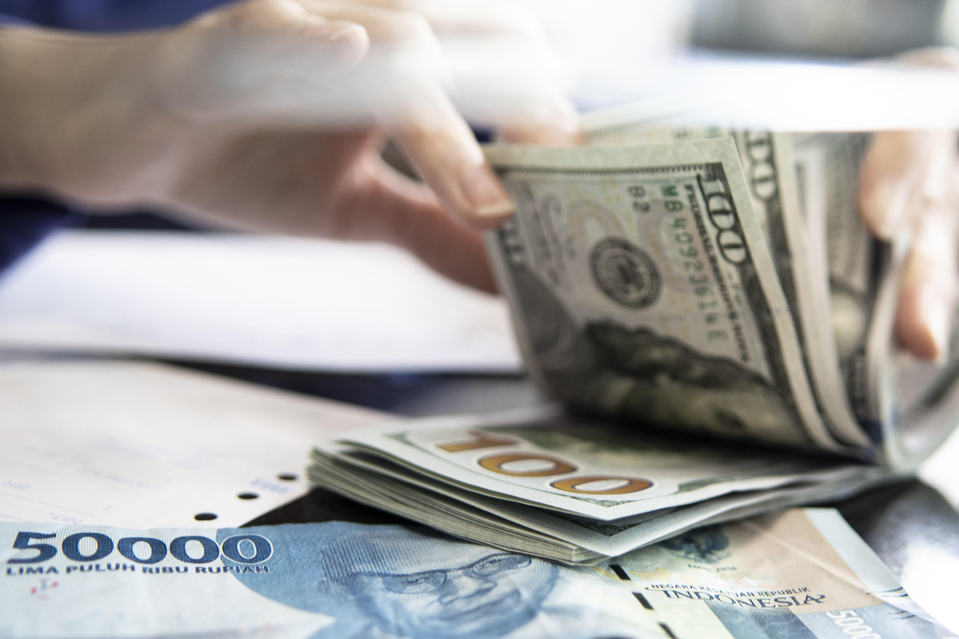 Petugas menghitung uang dolar AS di gerai penukaran mata uang asing VIP (Valuta Inti Prima) Money Changer, Jakarta, Jakarta, Rabu (16/11)