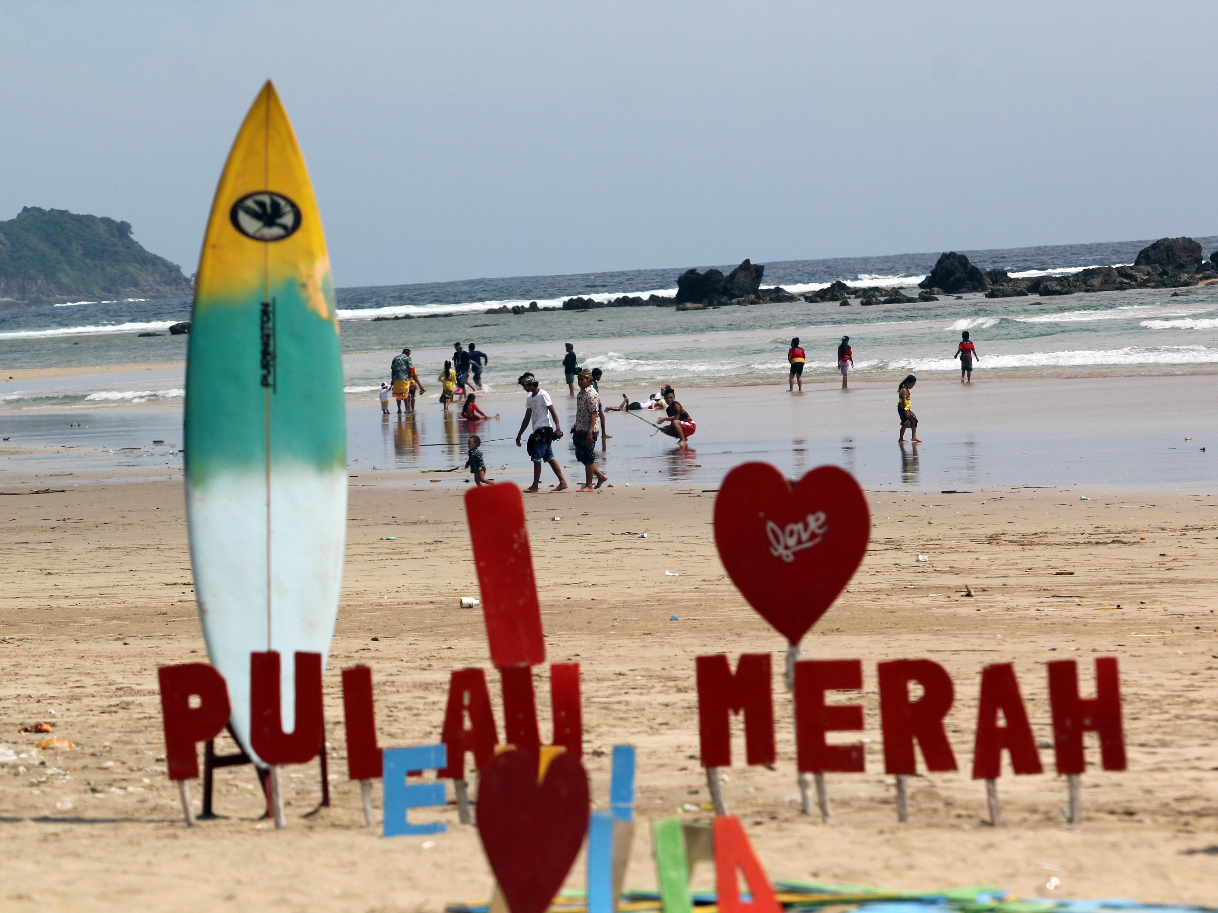 Sejumlah wisatawan menikmati suasana pantai Pulau Merah di Banyuwangi, Jawa Timur.