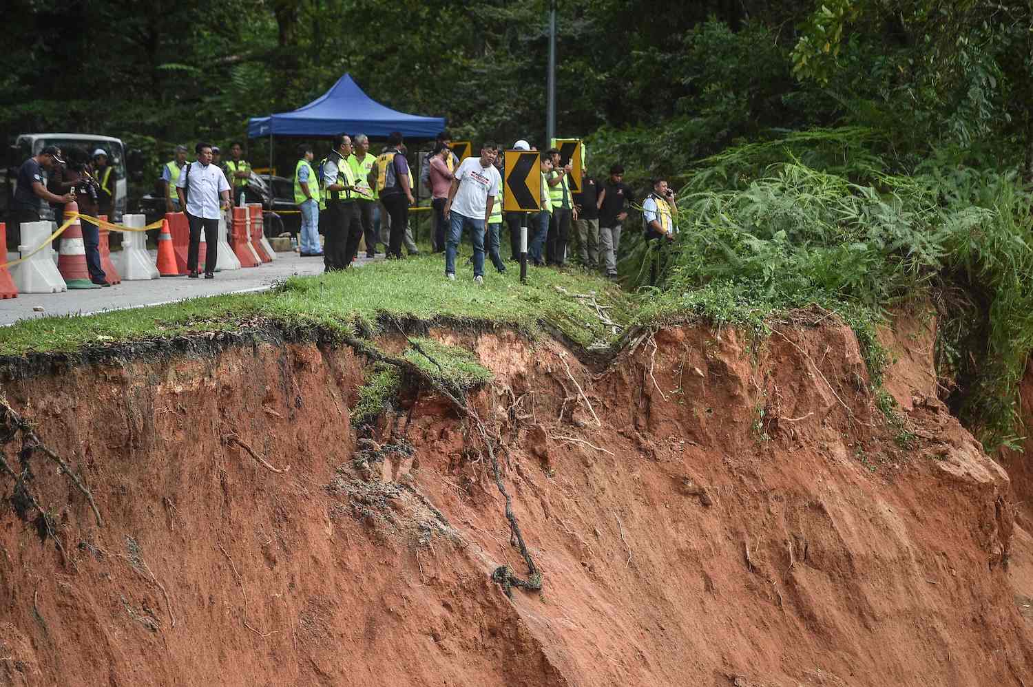 Warga menyaksikan tanah longsor yang mengubur lokasi kemping di Batang Kali sekitar 50 km dari Kuala Lumpur. Korban meninggal 21 orang.