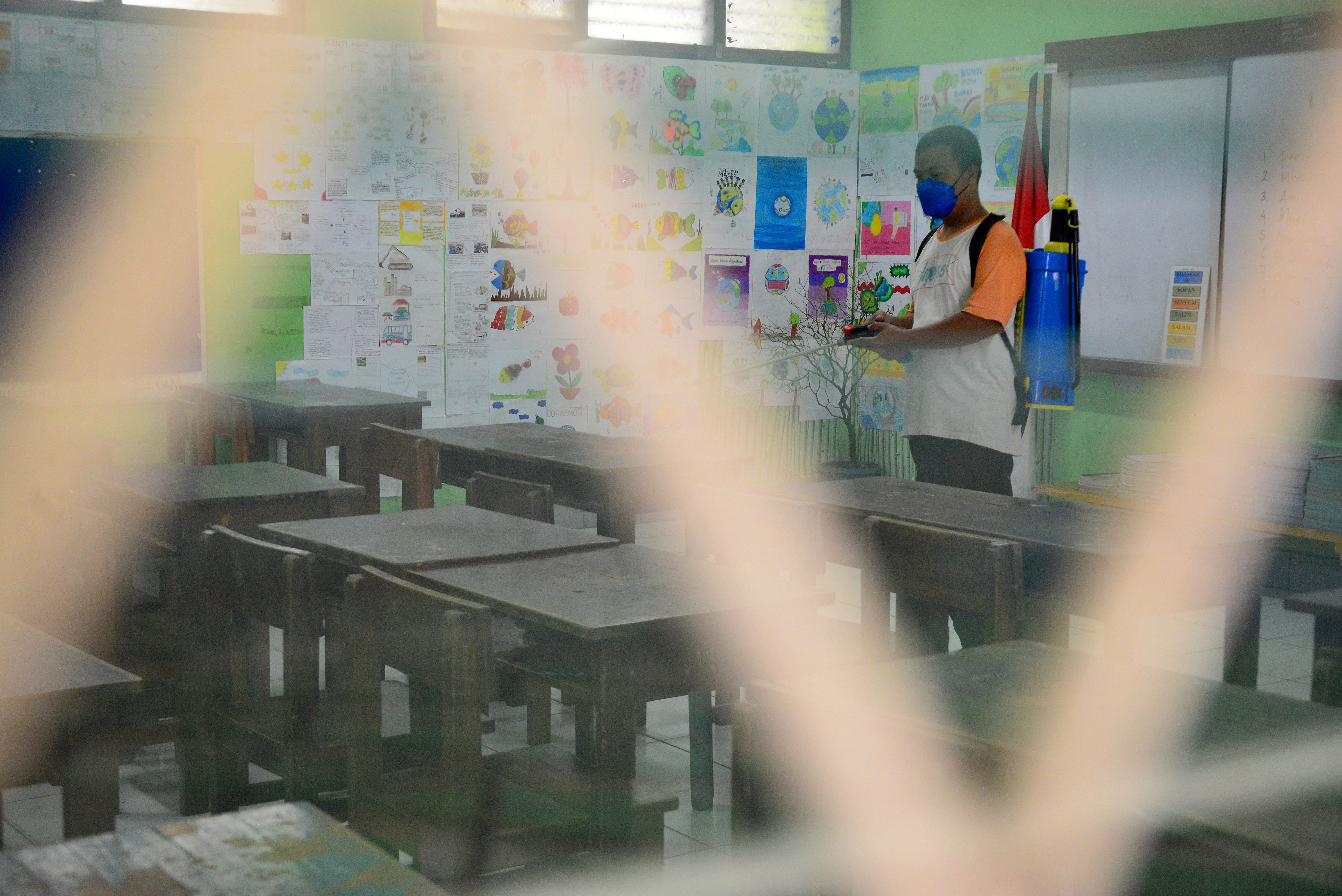 Potret penjaga sekolah membersihkan ruang kelas.