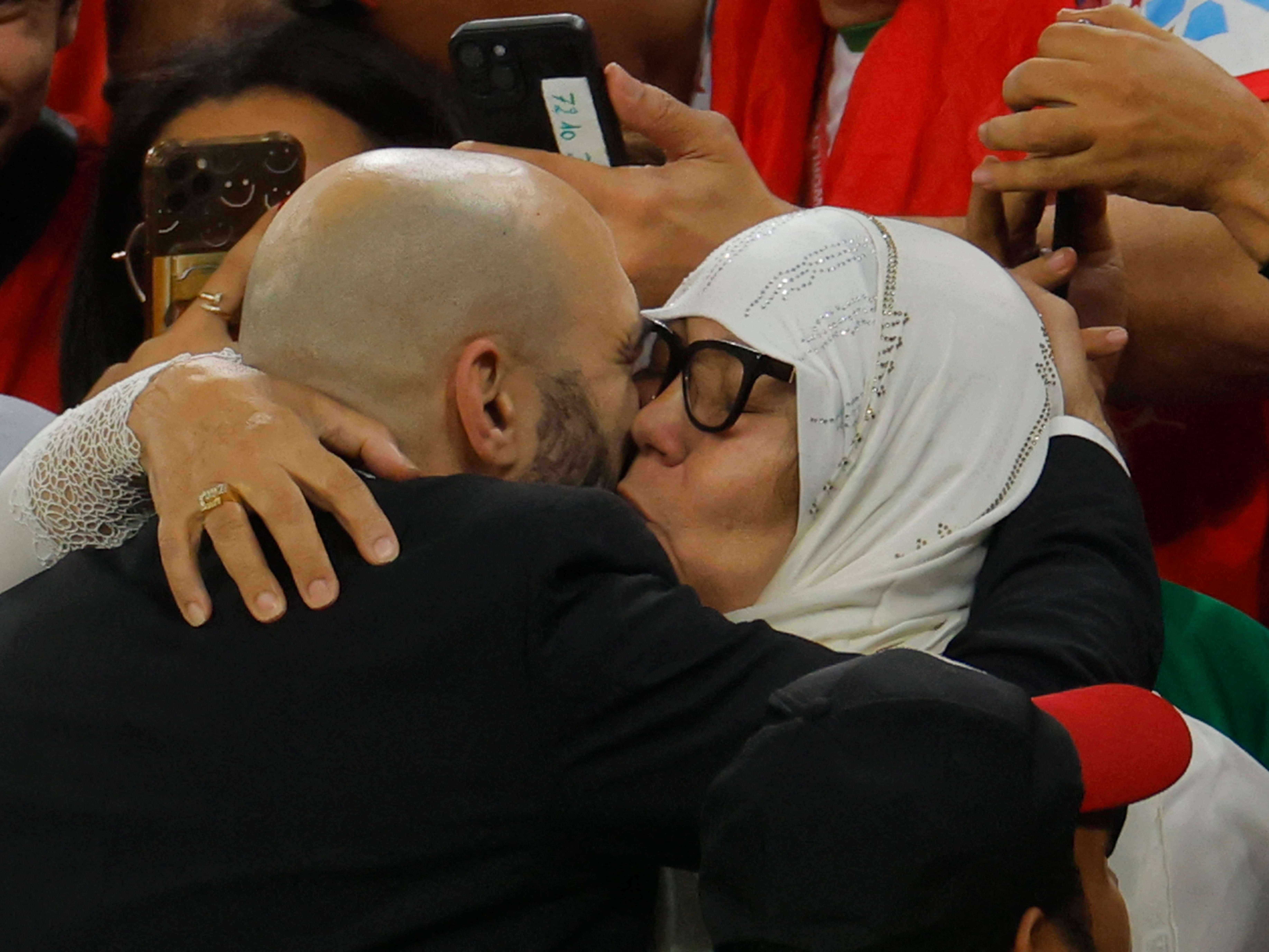Pelatih Maroko Walid Reragui (kiri) merayakan dengan seorang kerabat setelah memenangkan pertandingan sepak bola perempat final Piala Dunia.