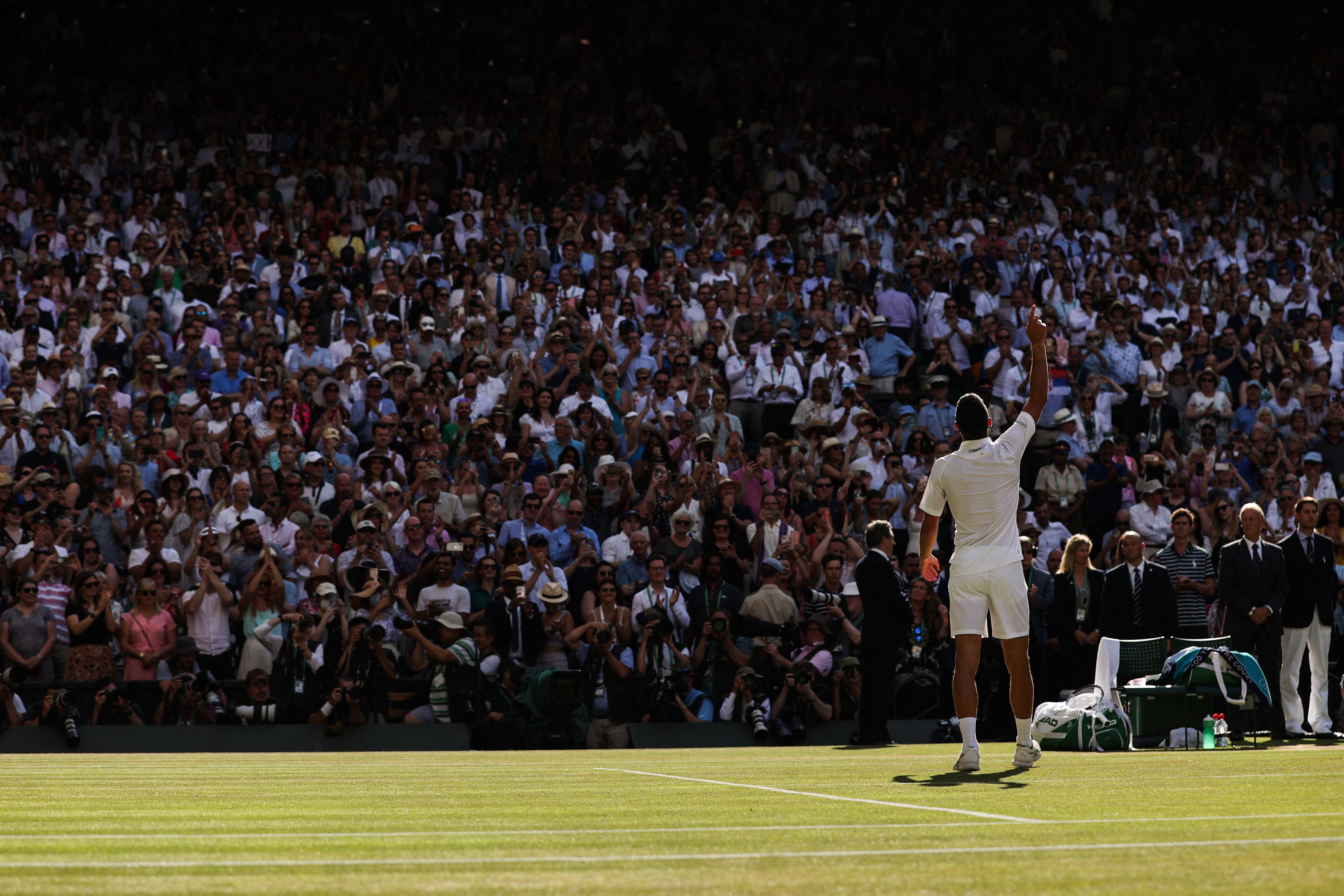 Petenis Serbia Novak Djokovic merayakan kemenangannya pada laga final dengan menyapa penggemar di Wimbledon 2022.
