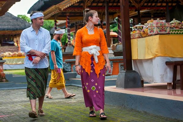 Wisatawan mancanegara mengenakan pakaian adat ketika melihat perayaan Hari Raya Galungan di Pura Dalem Peliatan, Ubud, Bali