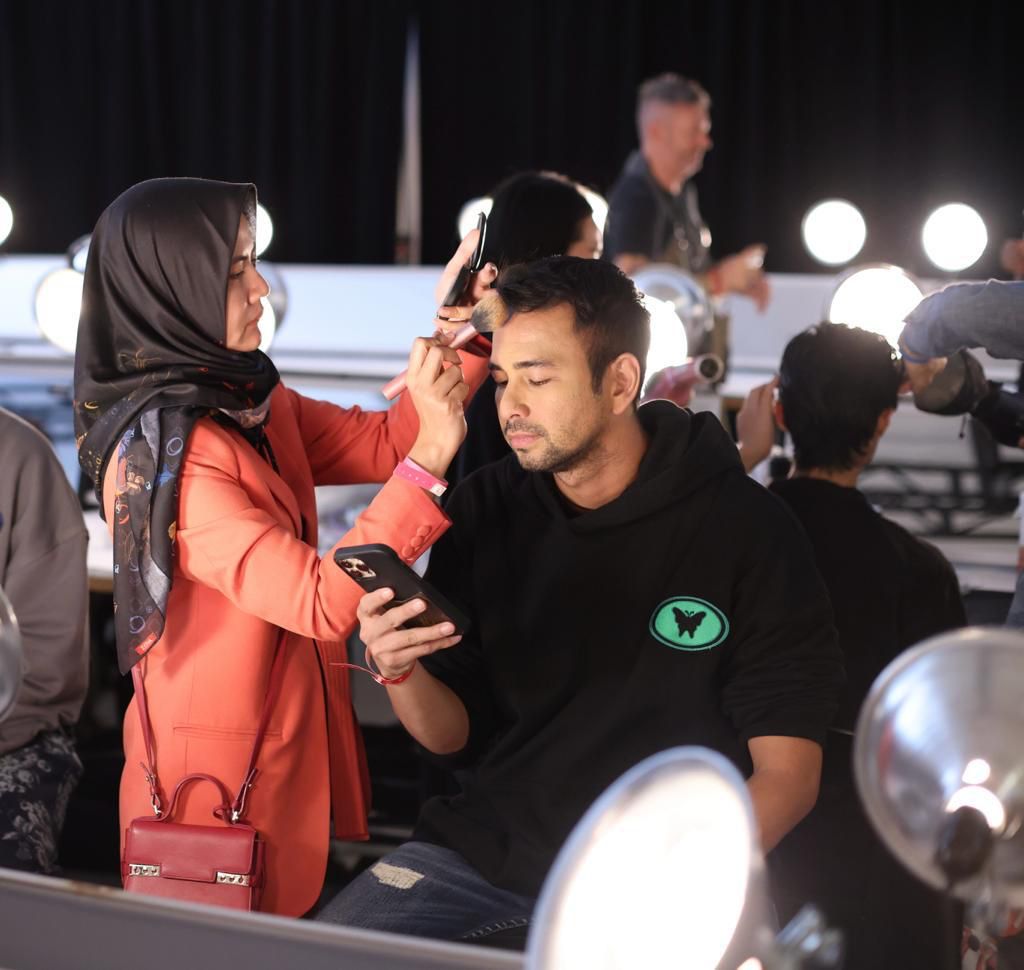 Make up artist Indah Aini sedang merias wajah presenter dan artis Raffi Ahmad sebelum naik tampil. 