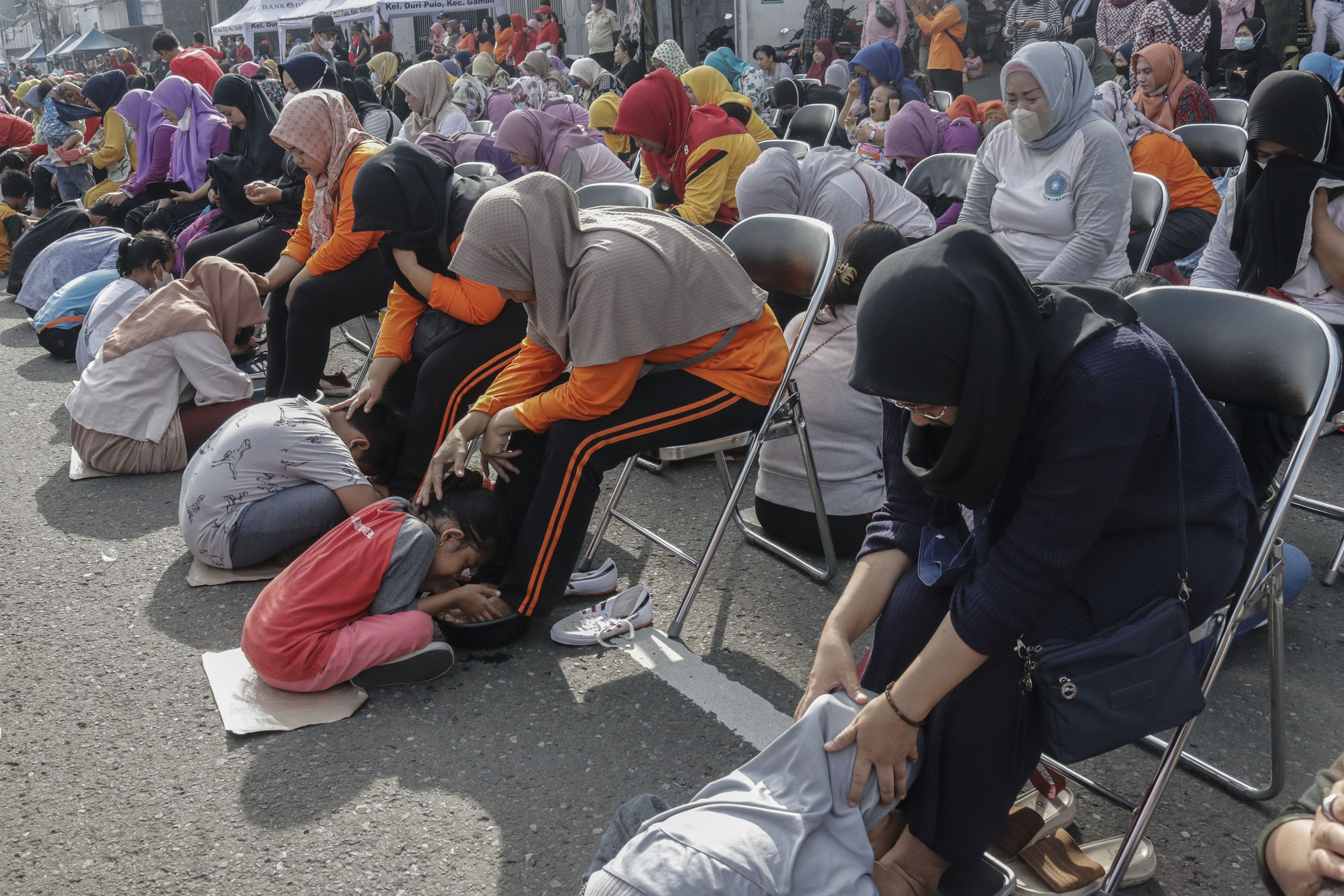 CINTA IBU: Sejumlah anak mencuci kaki ibu mereka dalam peringatan Hari Ibu di Gambir, Jakarta, Minggu (18/12/2022).
