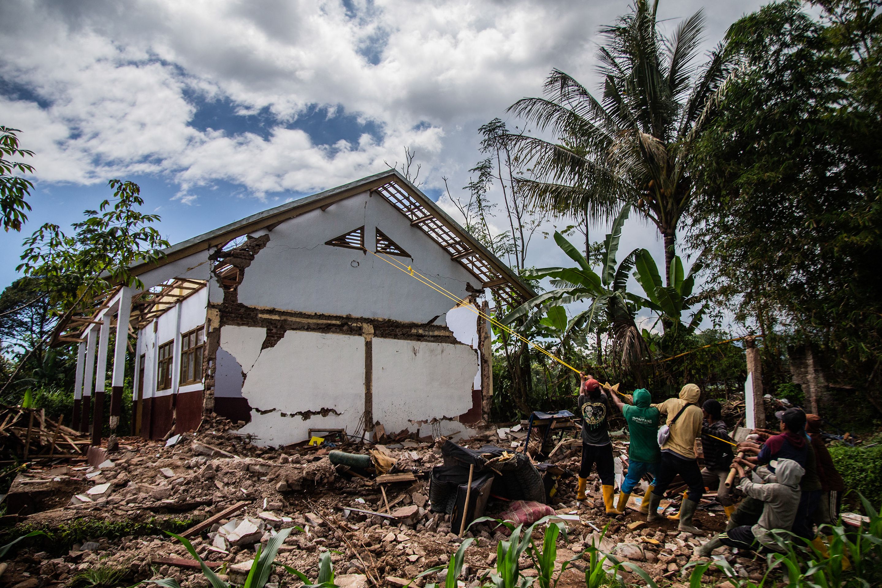 Para pekerja merobohkan rumah warga yang rusak berat akibat gempa Cianjur untuk dibangun kembali atau direlokasi ke tempat aman.