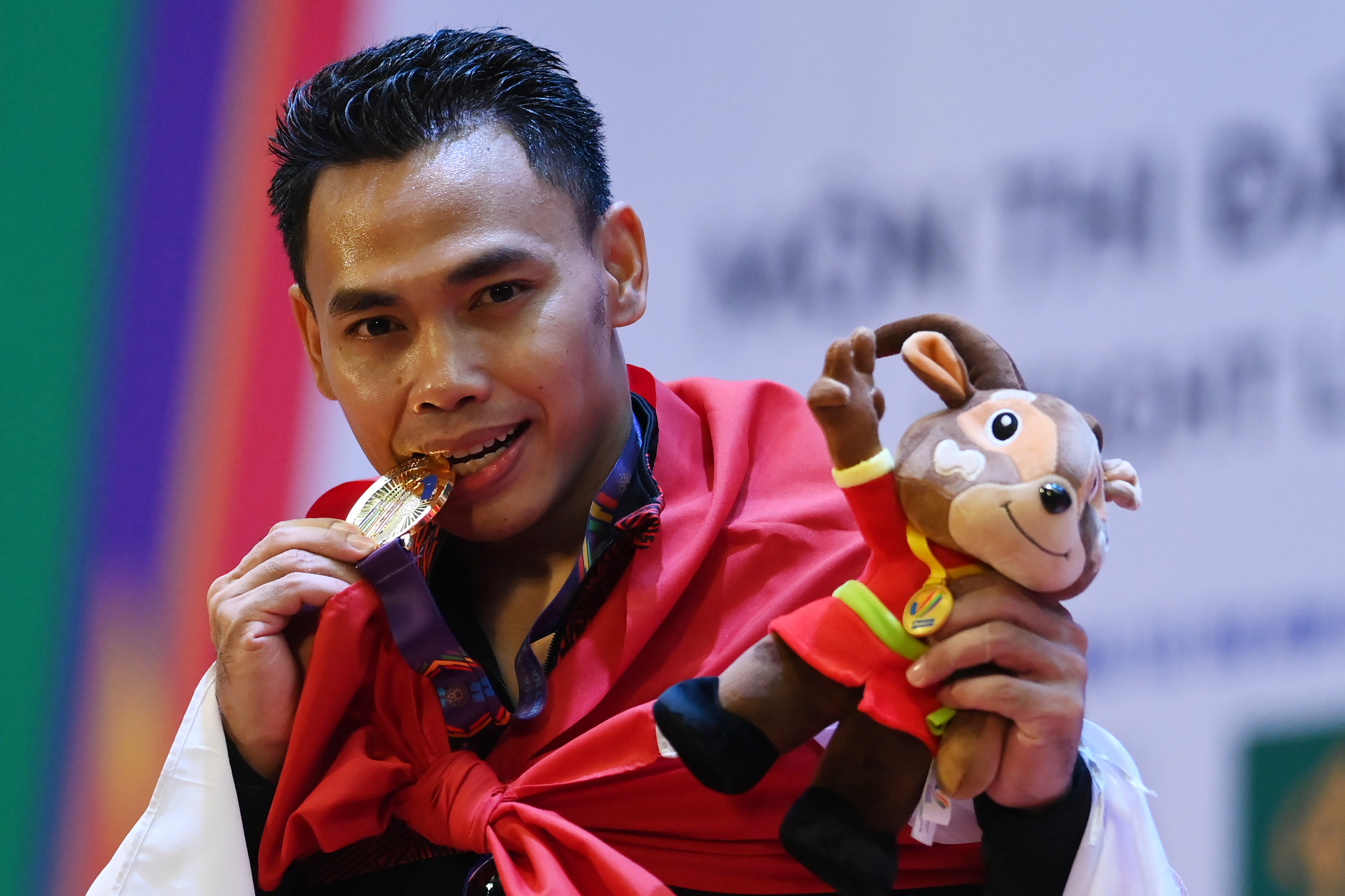 Lifter Indonesia Eko Yuli Irawan berpose dengan medali emas yang diraihnya pada SEA Games 2021 di Vietnam.