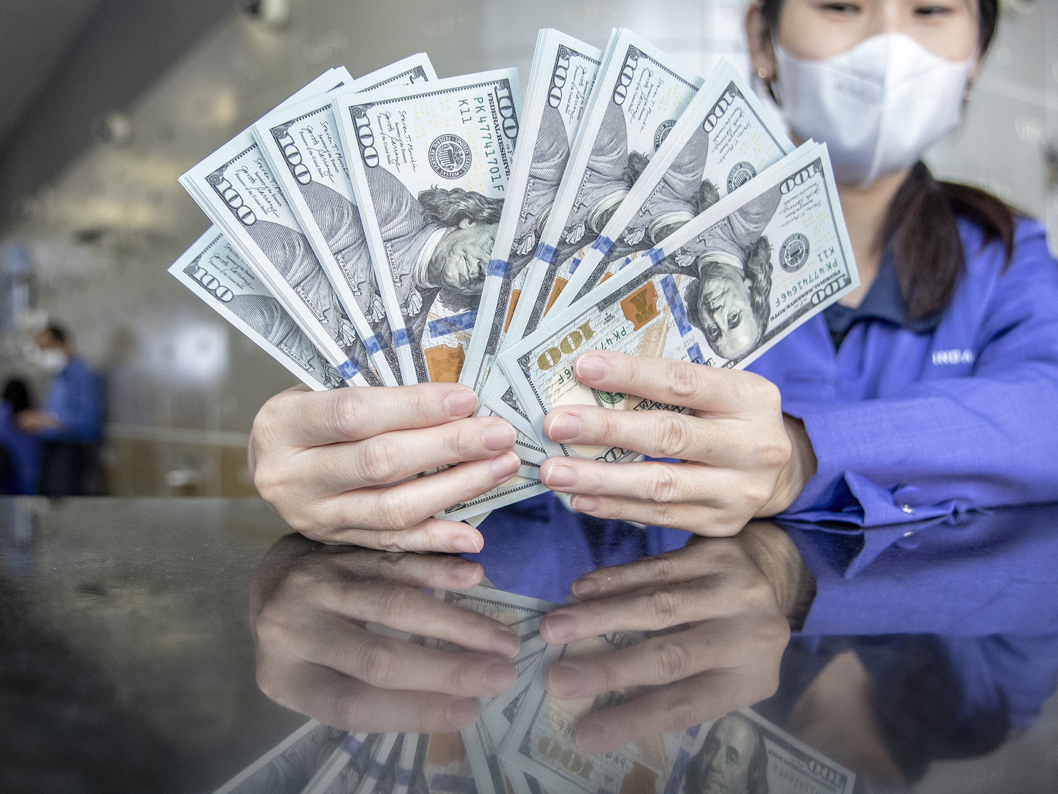 Petugas menunjukkan uang pecahan dolar AS di gerai penukaran mata uang asing VIP (Valuta Inti Prima) Money Changer, Jakarta.