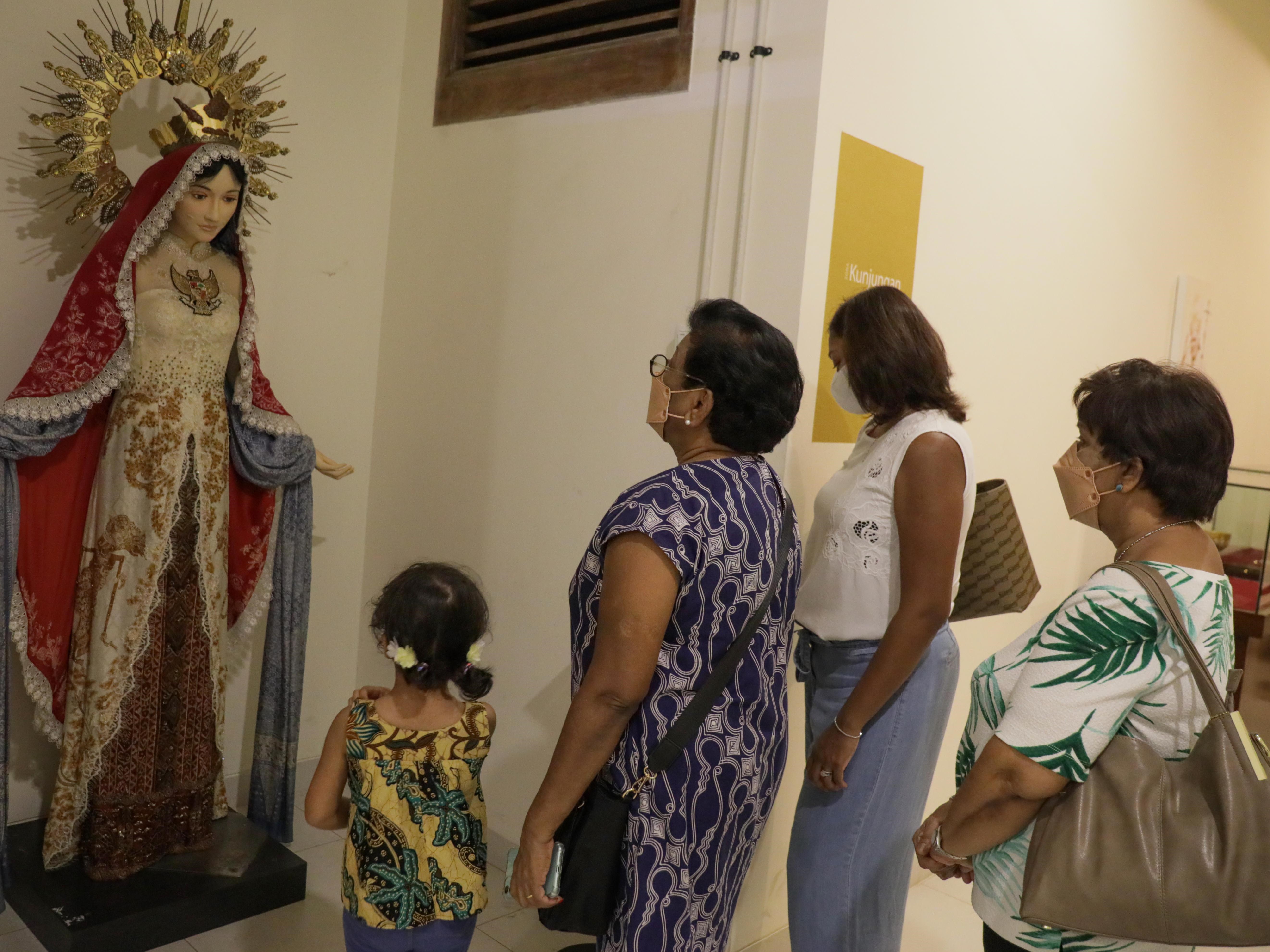 Pengunjung asal Singapura melihat koleksi Museum Gereja Katedral Patung Bunda Maria Segala Suku dalam rangkaian wisata religi.