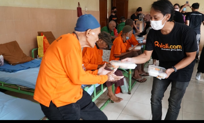 Karyawan Ralali memberikan bantuan makanan kepada penghuni Panti Sosial Werdha Budi Mulia