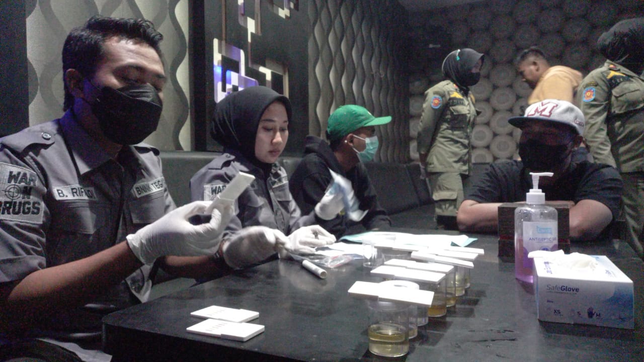 Sejumlah pengunjung tempat hiburan malam karaoke menjalani pemeriksaan petugas. 