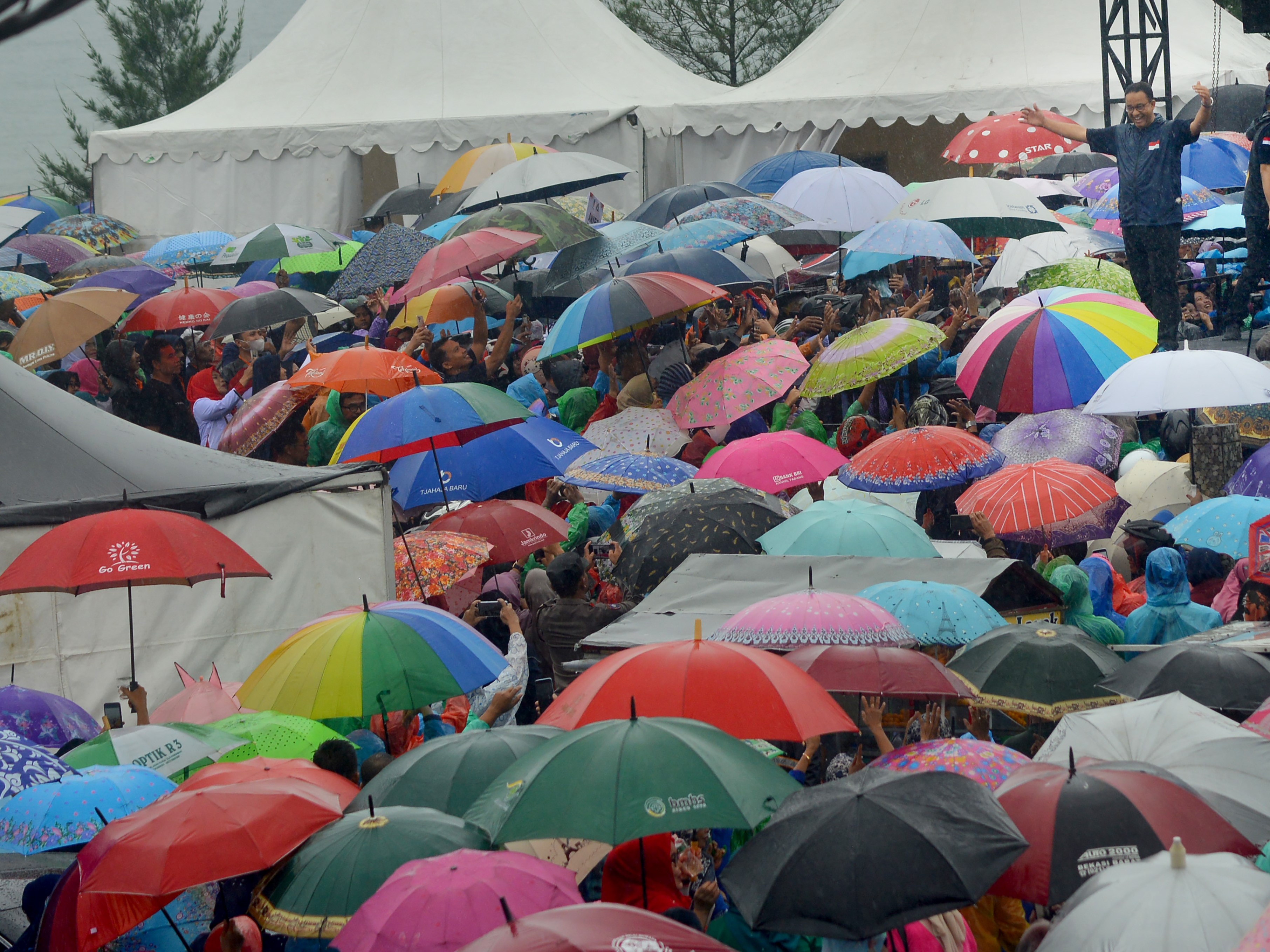 Bakal Calon Presiden dari Partai NasDem, Anies Baswedan (kanan), menyapa warga sebelum orasi di Pantai Padang, Sumatra Barat, Minggu (4/12).