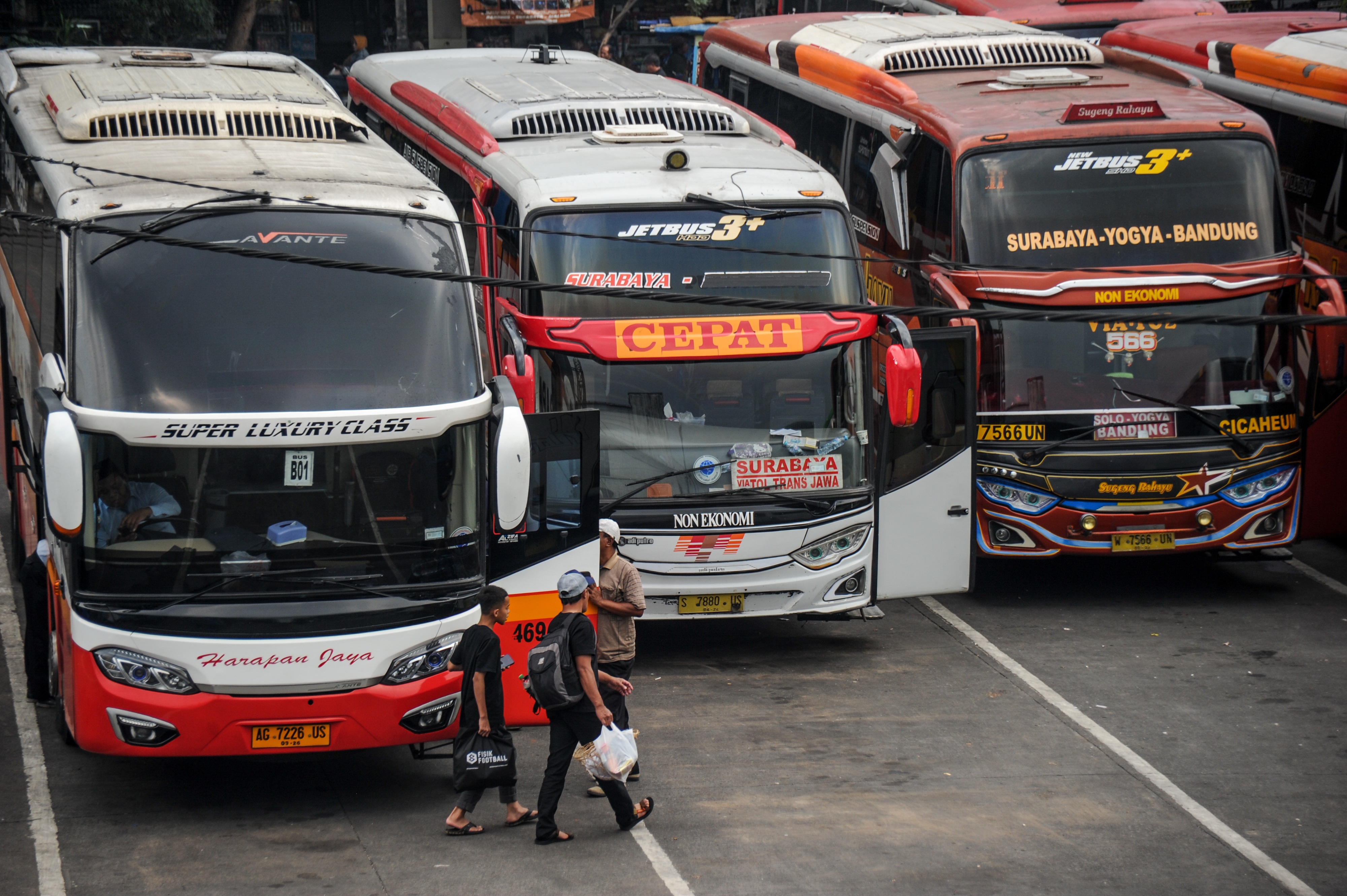 Calon penumpang berjalan menuju ke dalam bus di Terminal Cicaheum, Bandung, Jawa Barat.