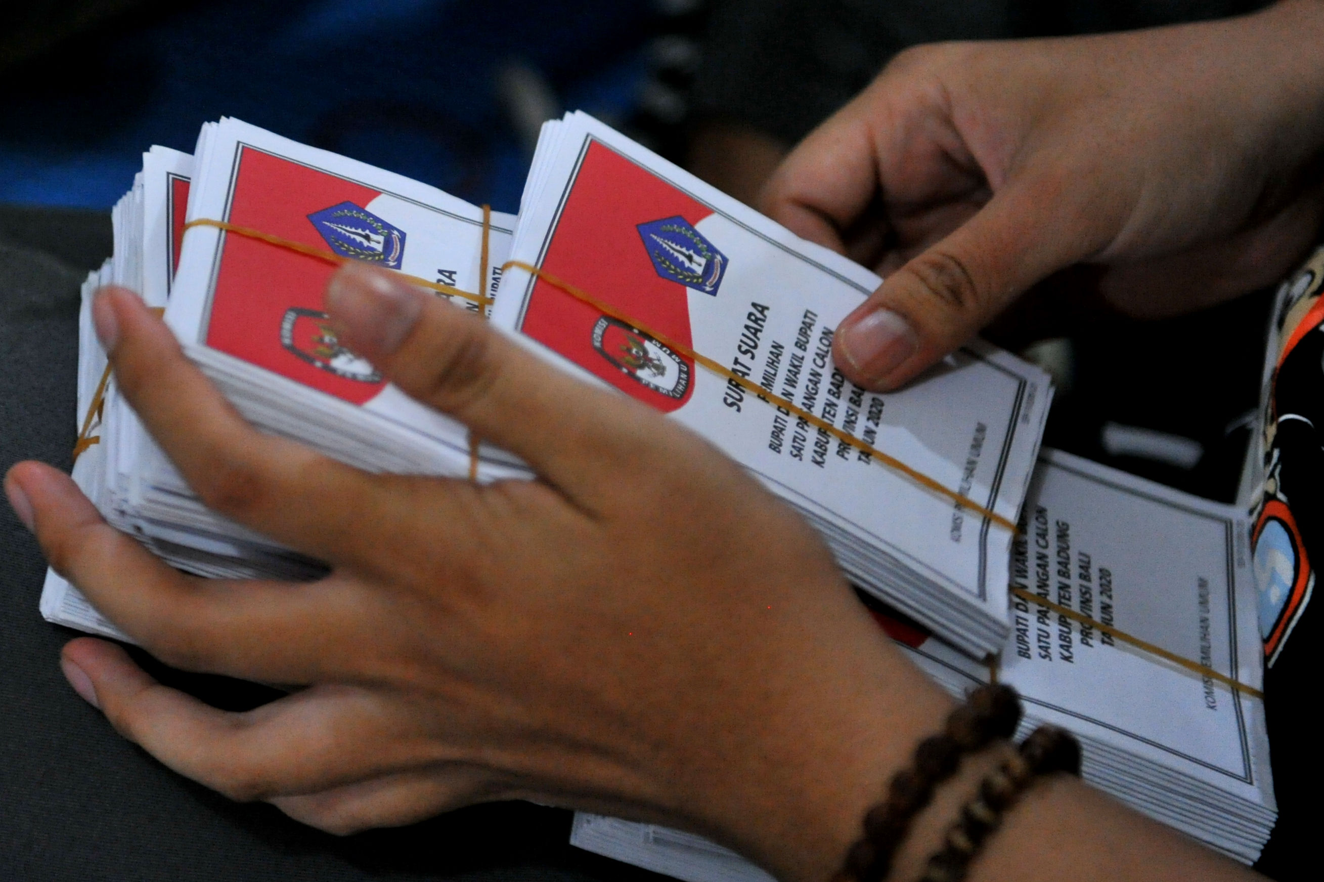 Potret petugas memeriksa suarat suara yang telah dilipat.