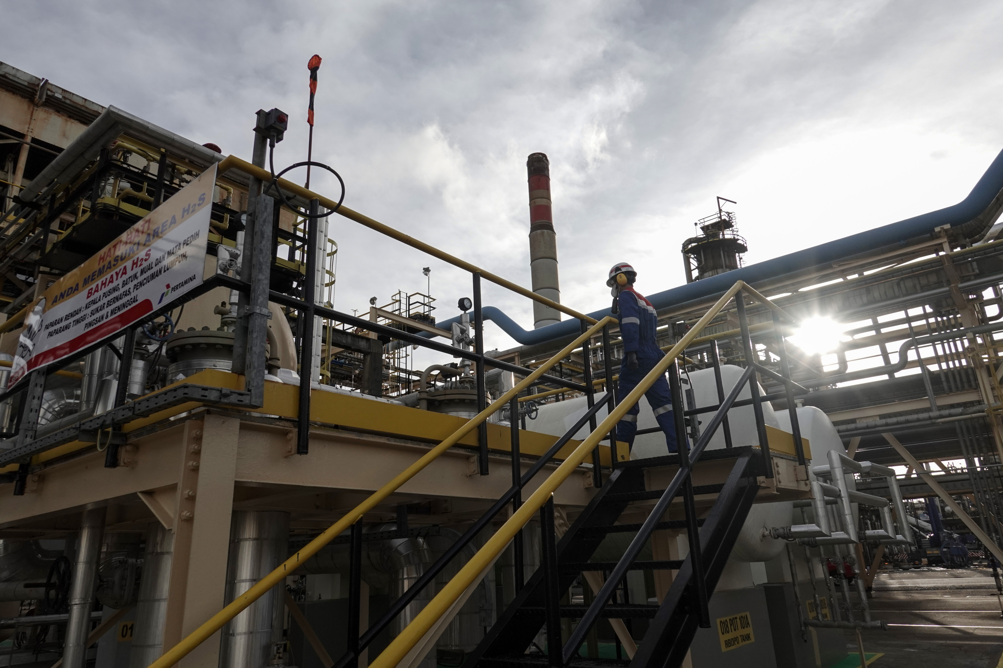 Ilustrasi petugas melakukan pemeriksaaan di area kilang minyak.