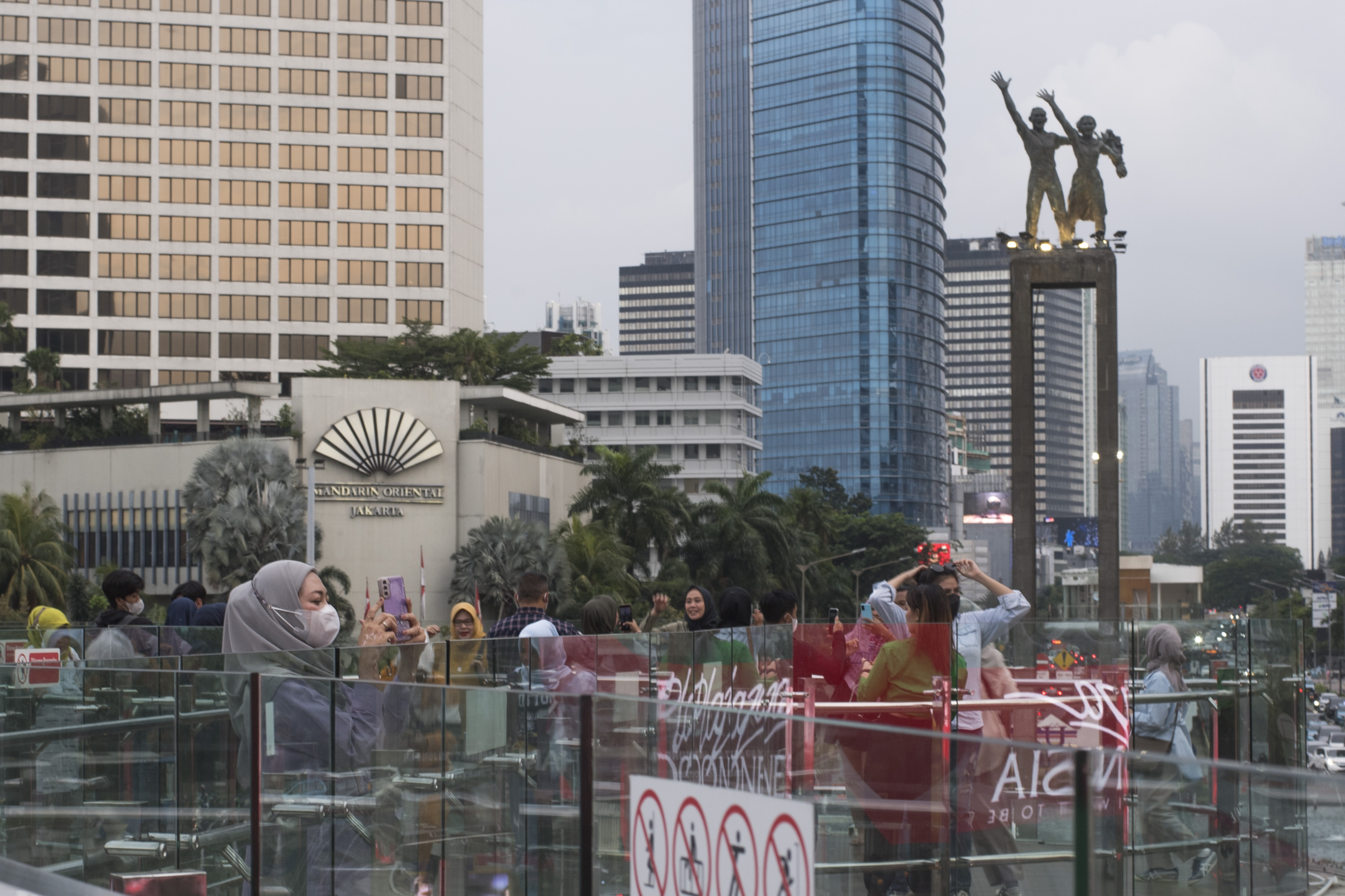  Sejumlah pengunjung berfoto dengan latar belakang patung selamat datang di Bundaran HI Jakarta.
