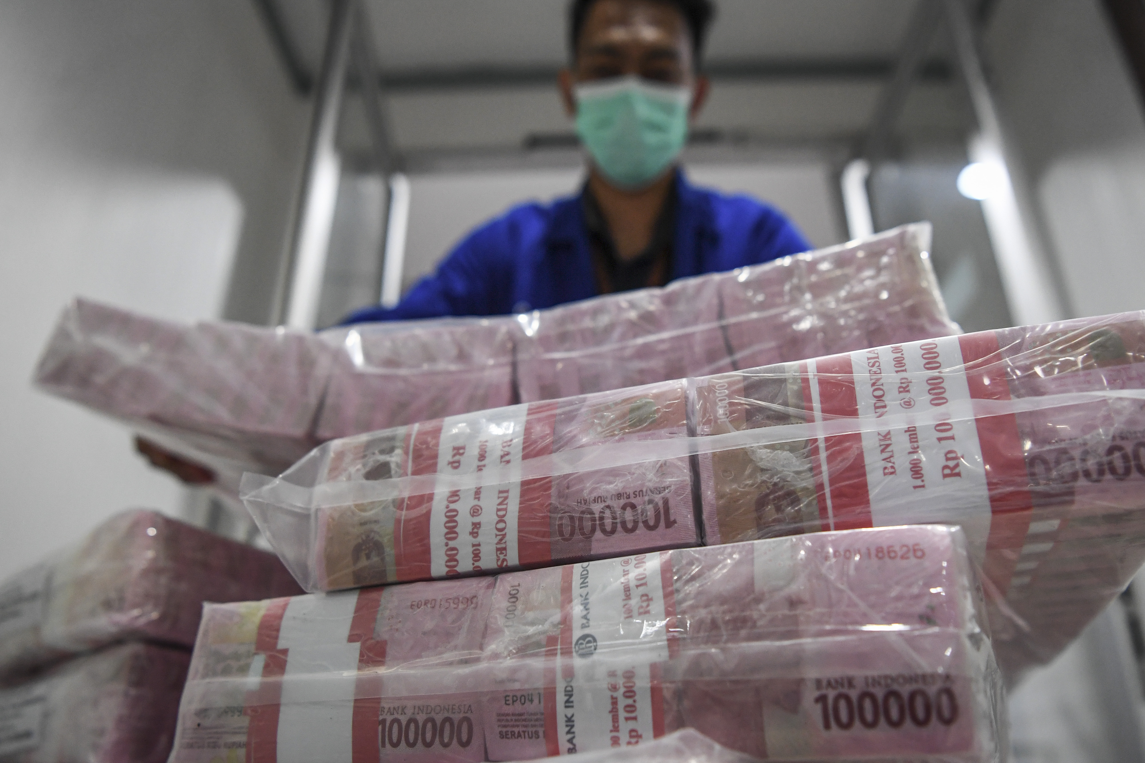 Petugas menata uang tunai sebelum didistribusikan melalui kantor cabang dan mesin ATM.