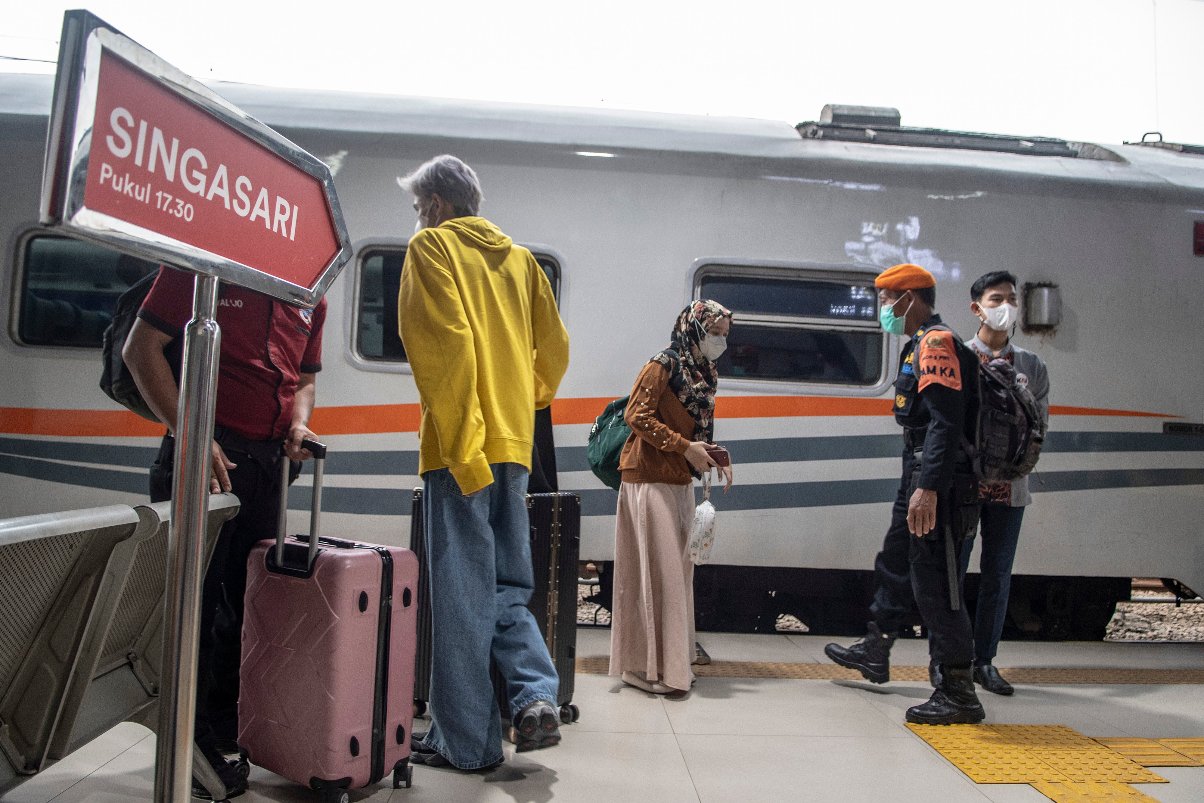 Calon penumpang kereta api berjalan di peron Stasiun Pasar Senen