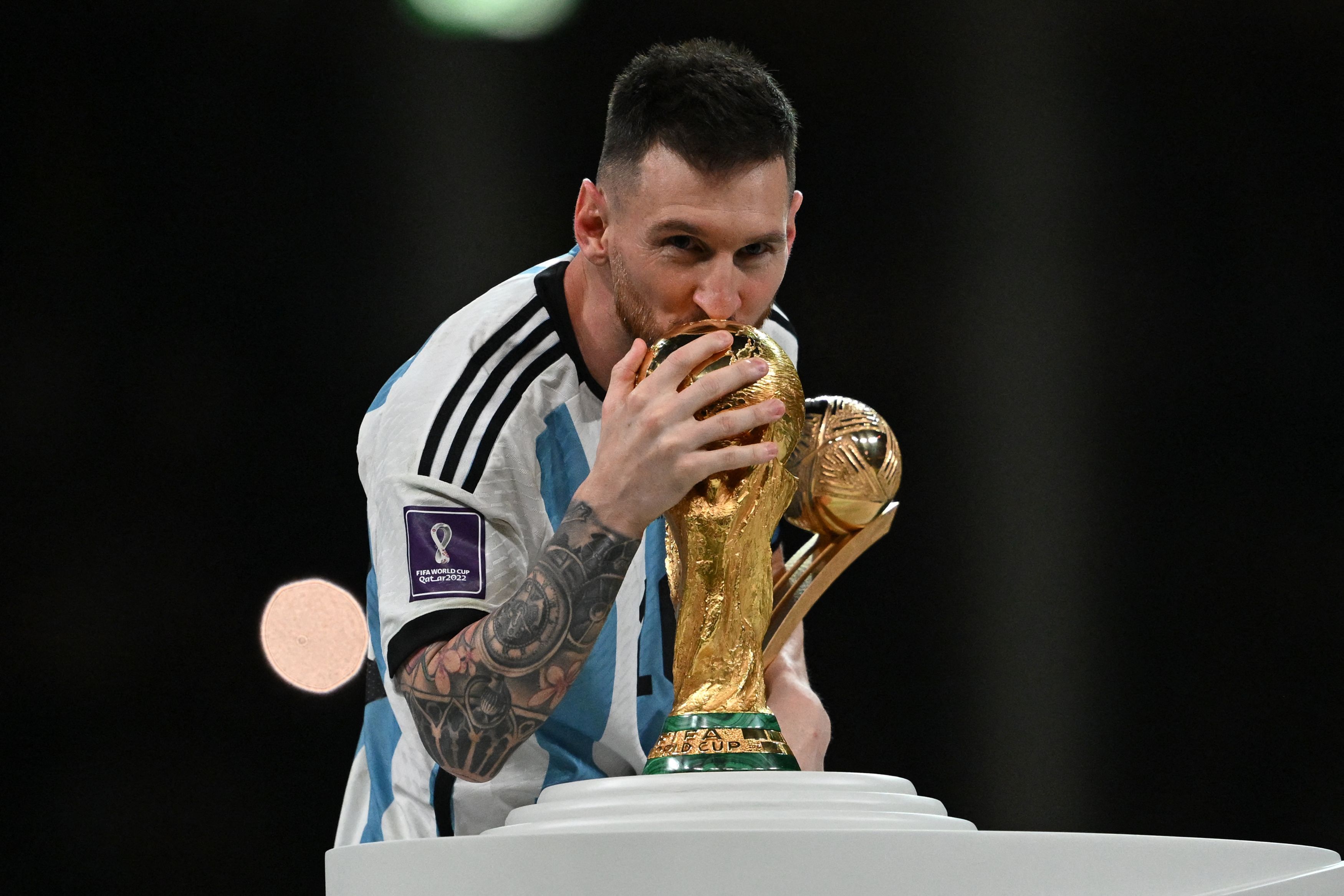 Lionel Messi mencium trofi Piala Dunia. Argentina menang 4-2 atas Prancis melalui adu penalti di final Piala Dunia 2022 Qatar.