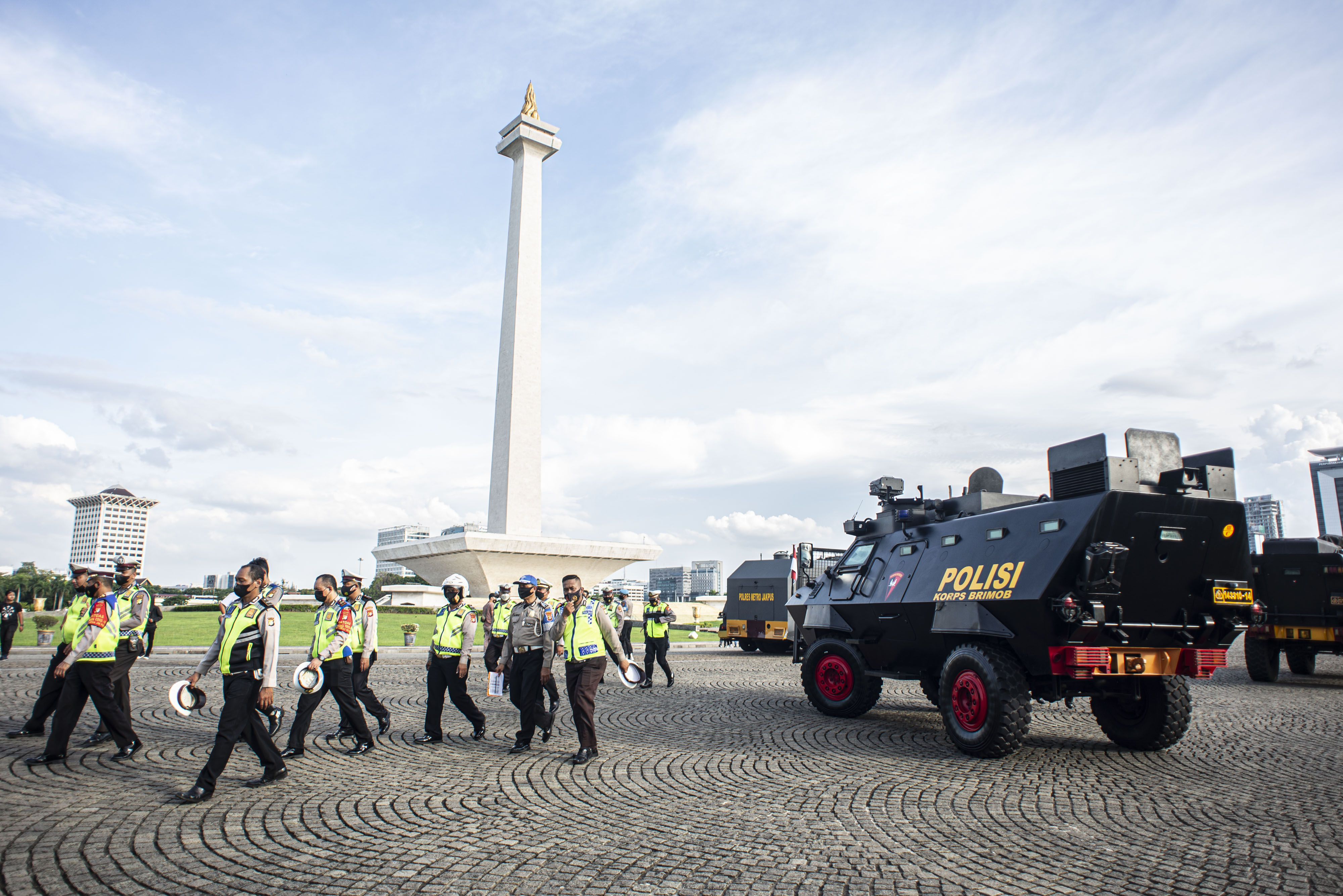 Personel kepolisian berjalan seusai mengikuti apel pengamanan di kawasan Monas, Jakarta.