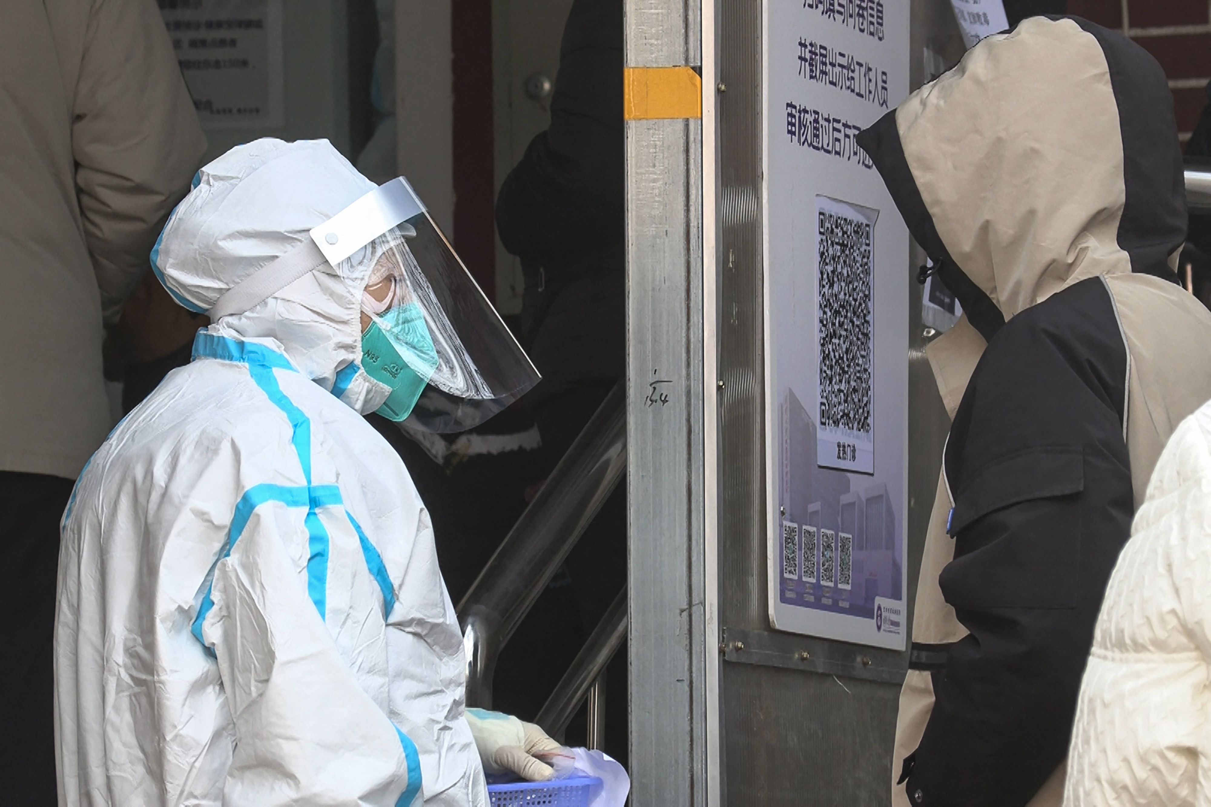 Seorang petugas medis tengah melayani pekerja yang akan melakukan tes covid-19 di Beijing, Rabu (14/12).