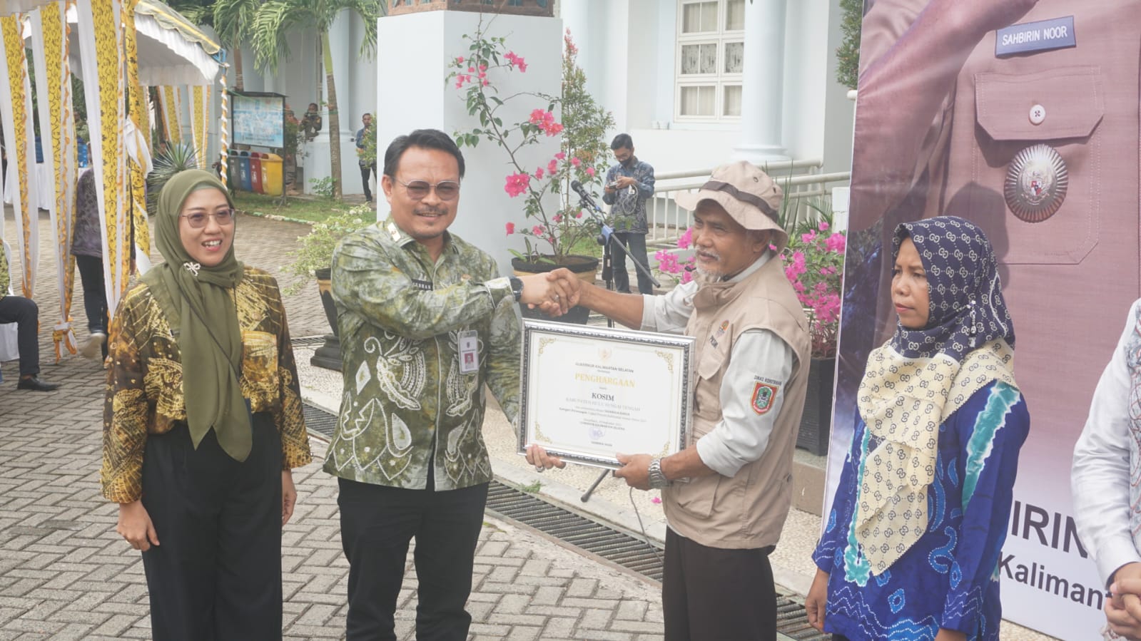 Asisten Administrasi Umum Setdaprov Kalsel, Subhan Nor Yaumil menyerahkan penghargaan kepada Kosim