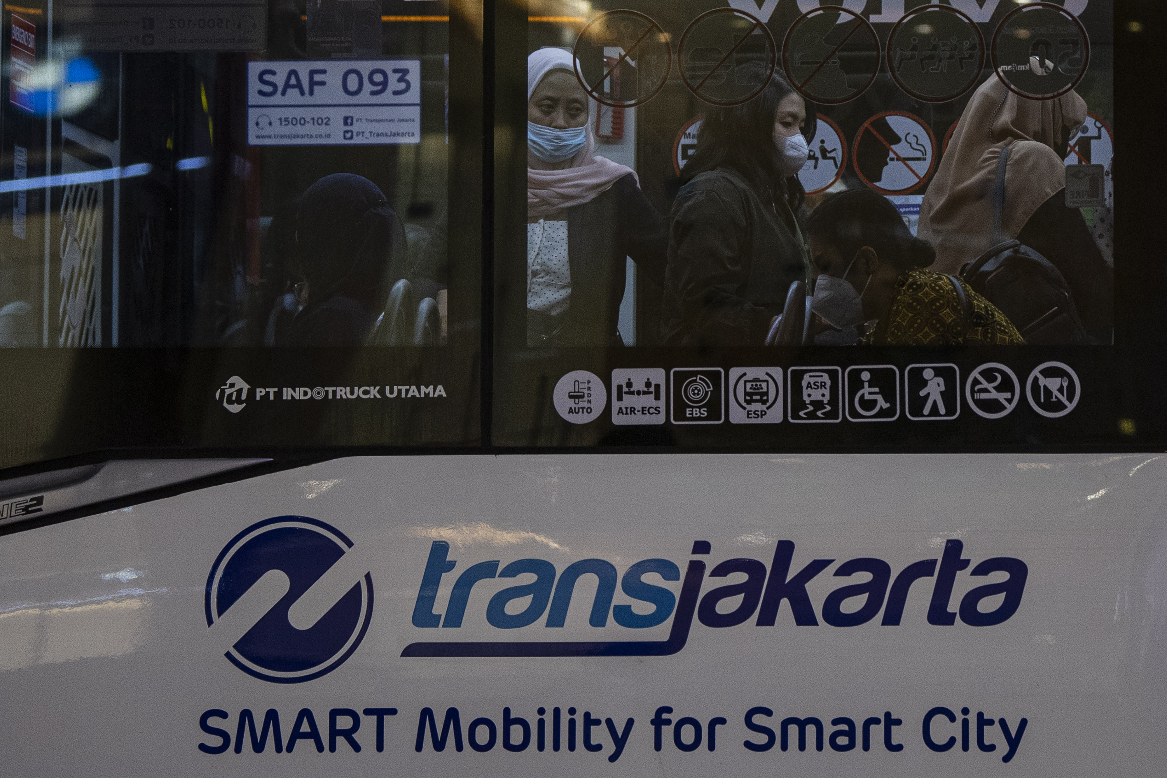 Potret penumpang berdiri di dalam bus TransJakarta.