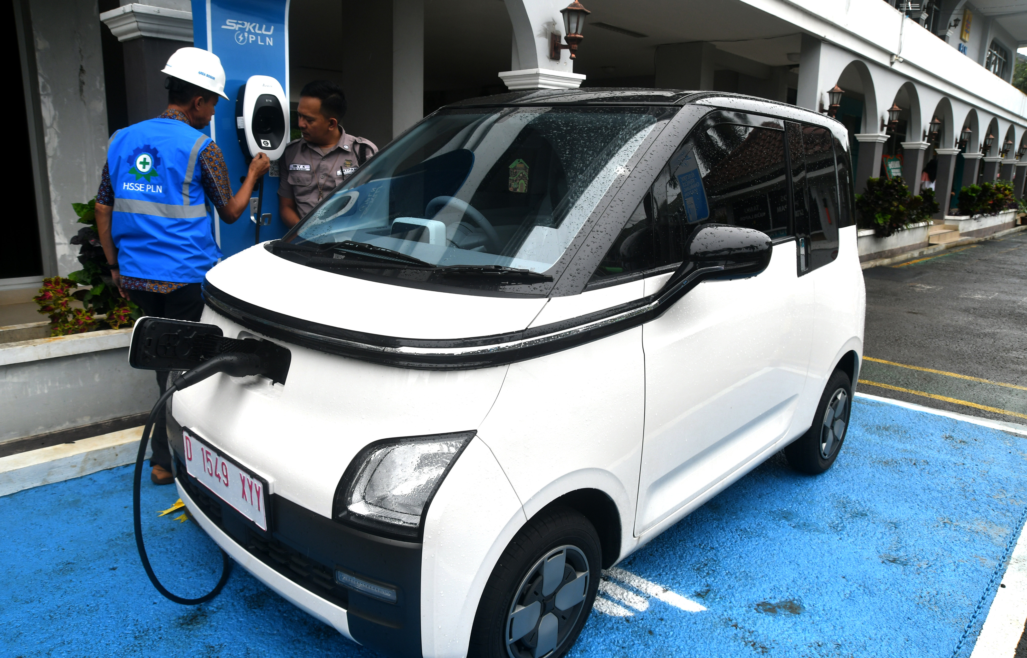 Petugas melakukan pengisian ulang daya baterai untuk mobil listrik di SPKLU PLN.