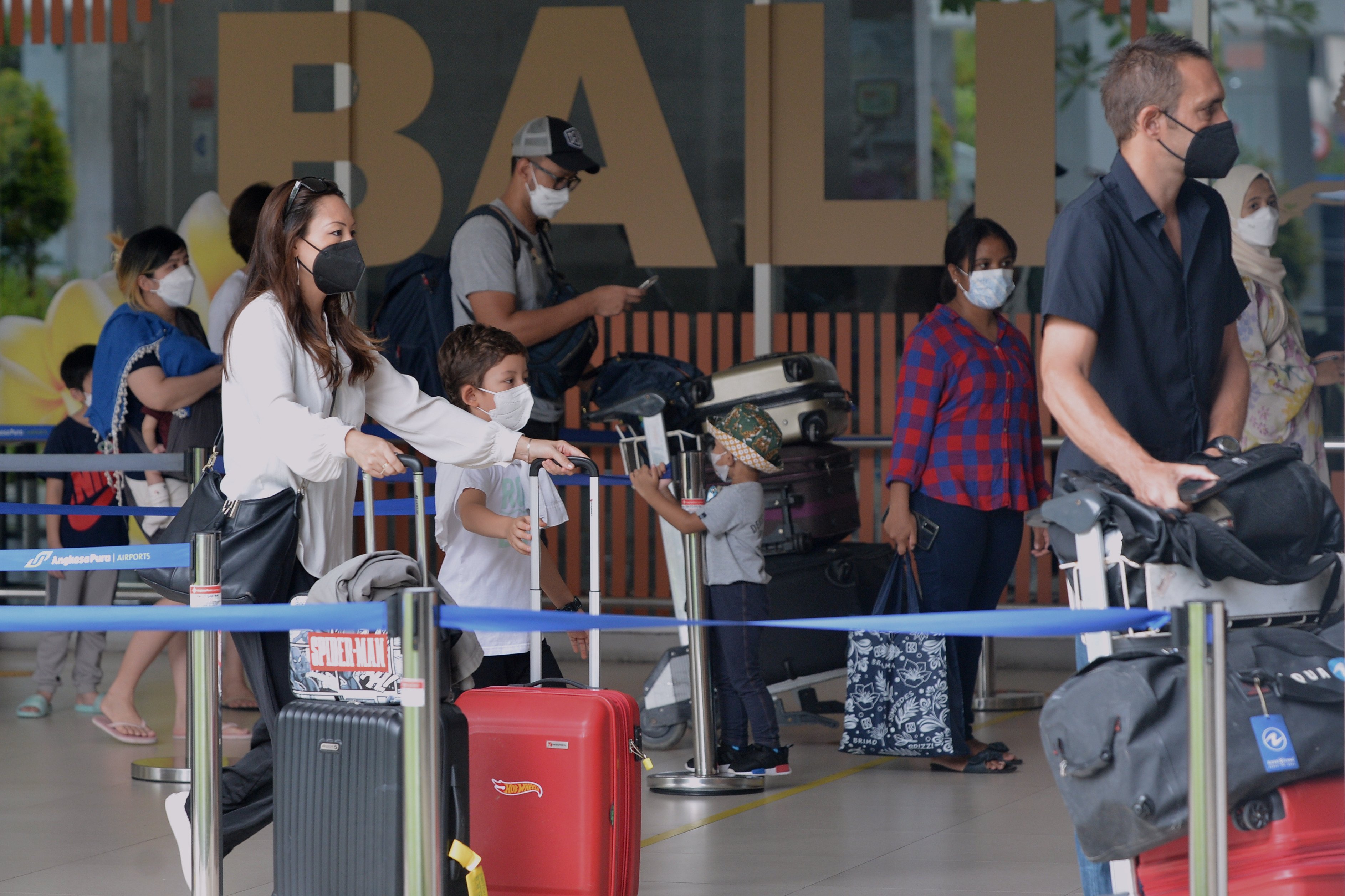 Calon penumpang pesawat berjalan masuk ke Terminal Keberangkatan Domestik Bandara Internasional I Gusti Ngurah Rai, Bali, untuk berlibur.